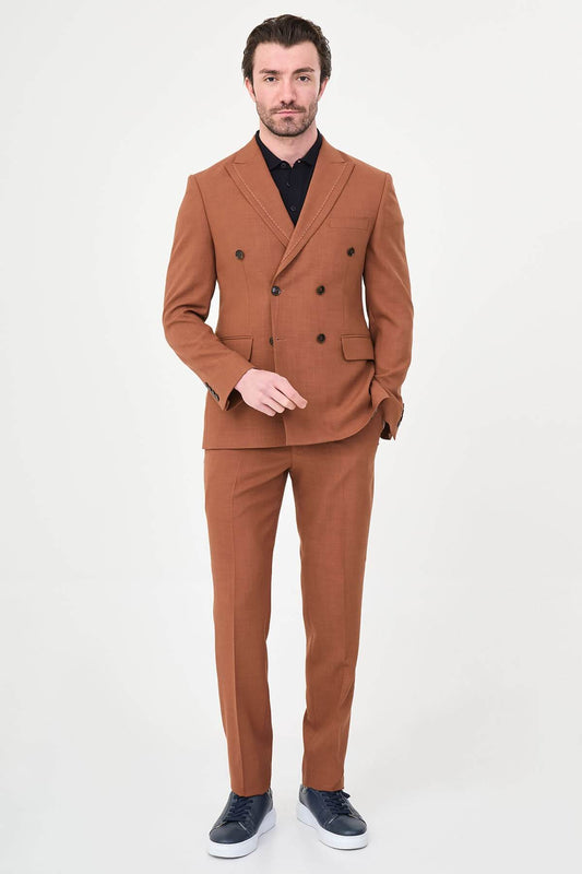 a Tile slim-fit double-breasted suit with peak lapels, contrast pick stitching, matching trousers, a black knit polo, and dark minimalist sneakers.