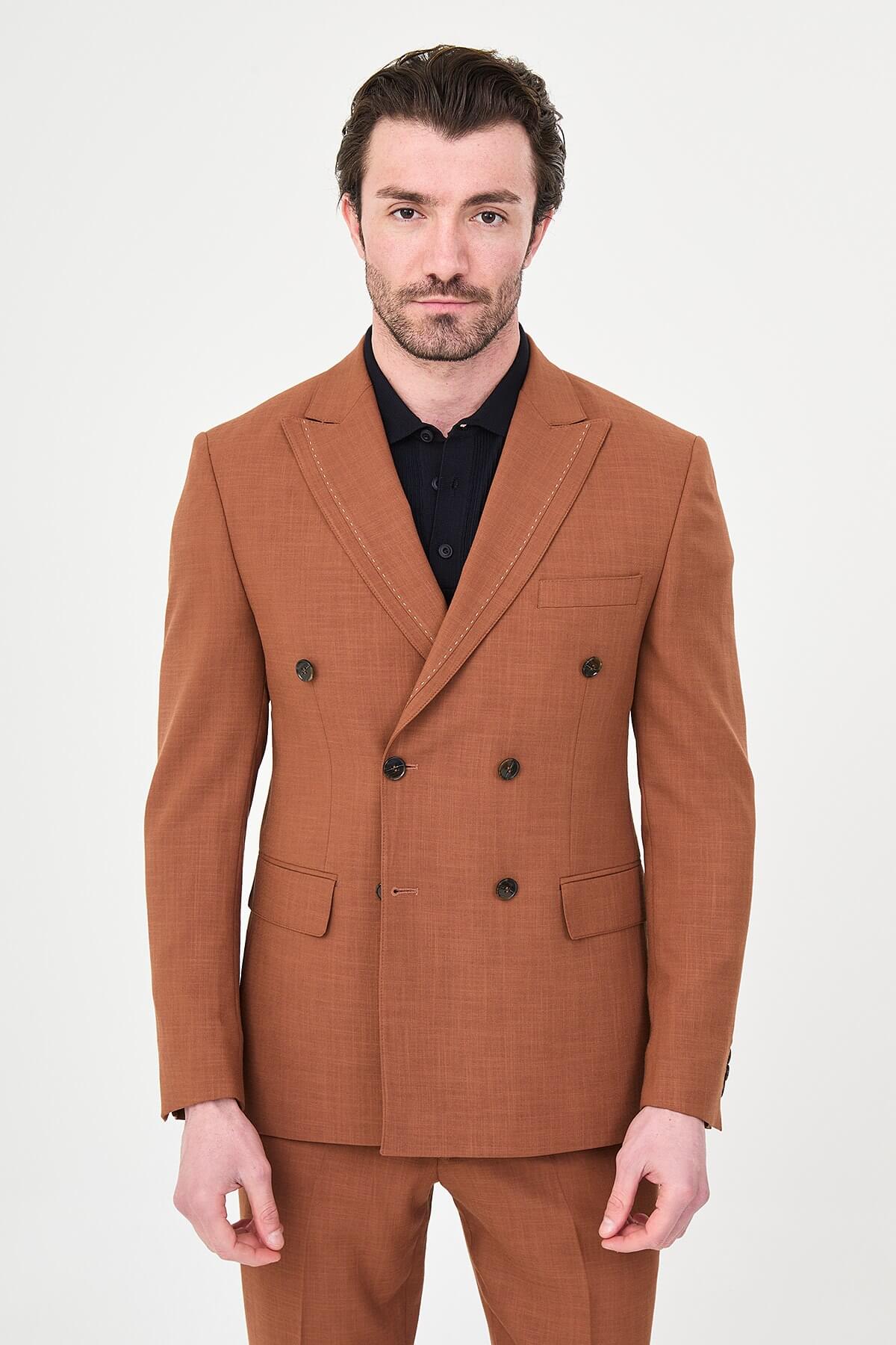 a Tile slim-fit double-breasted suit with peak lapels, contrast pick stitching, matching trousers, a black knit polo, and dark minimalist sneakers.