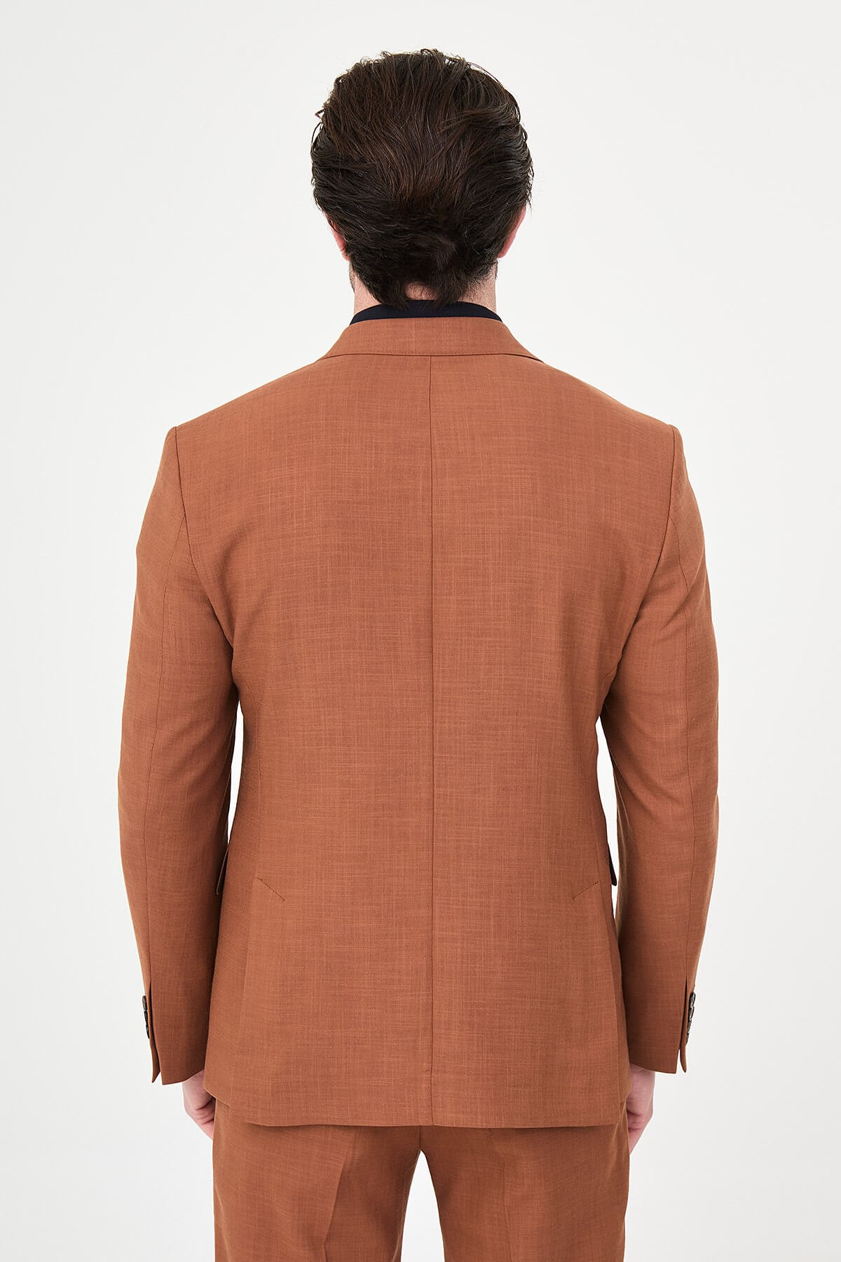 a Tile slim-fit double-breasted suit with peak lapels, contrast pick stitching, matching trousers, a black knit polo, and dark minimalist sneakers.