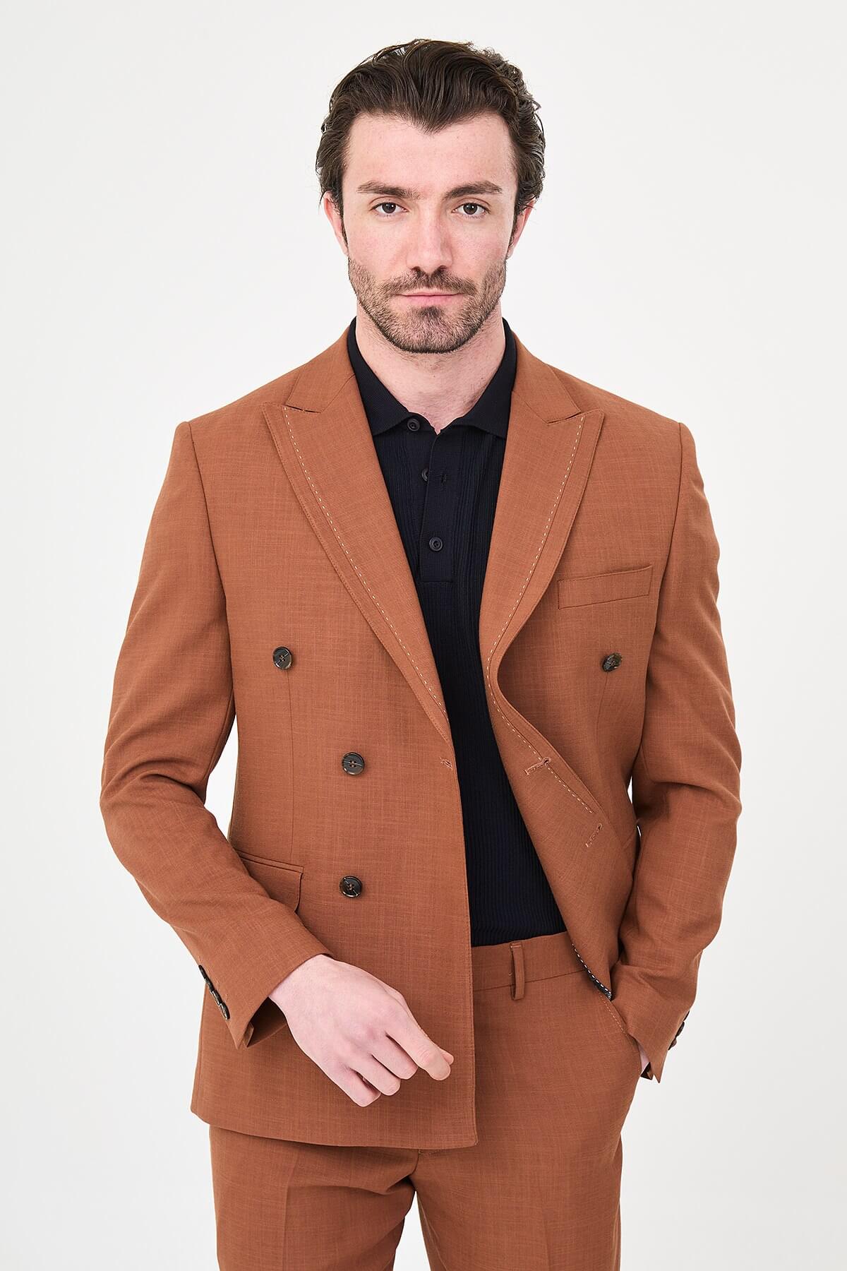 a Tile slim-fit double-breasted suit with peak lapels, contrast pick stitching, matching trousers, a black knit polo, and dark minimalist sneakers.