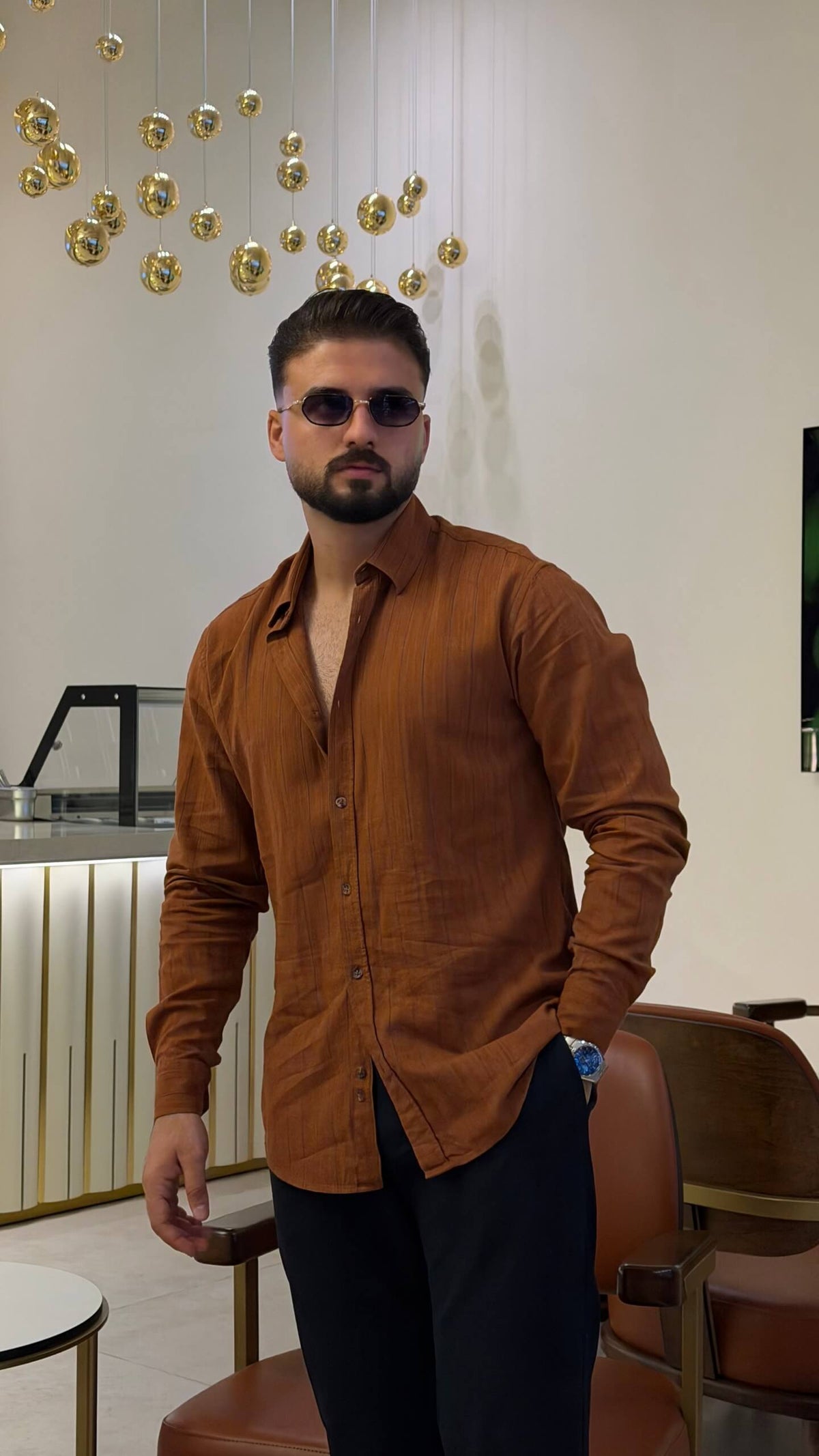 Men’s tile brown long sleeve cotton button-up shirt styled with black trousers and brown sneakers