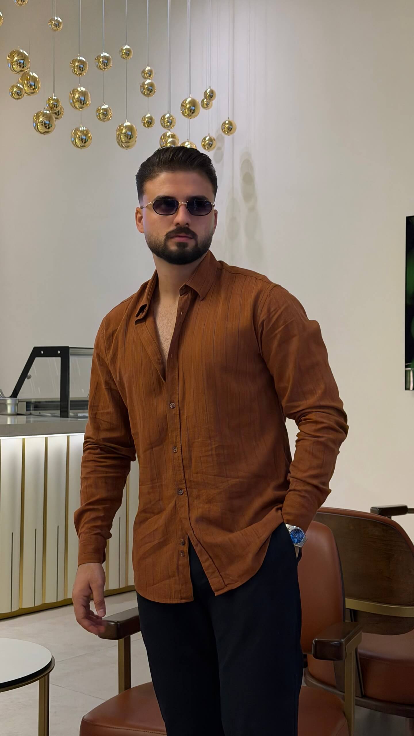 Men’s tile brown long sleeve cotton button-up shirt styled with black trousers and brown sneakers