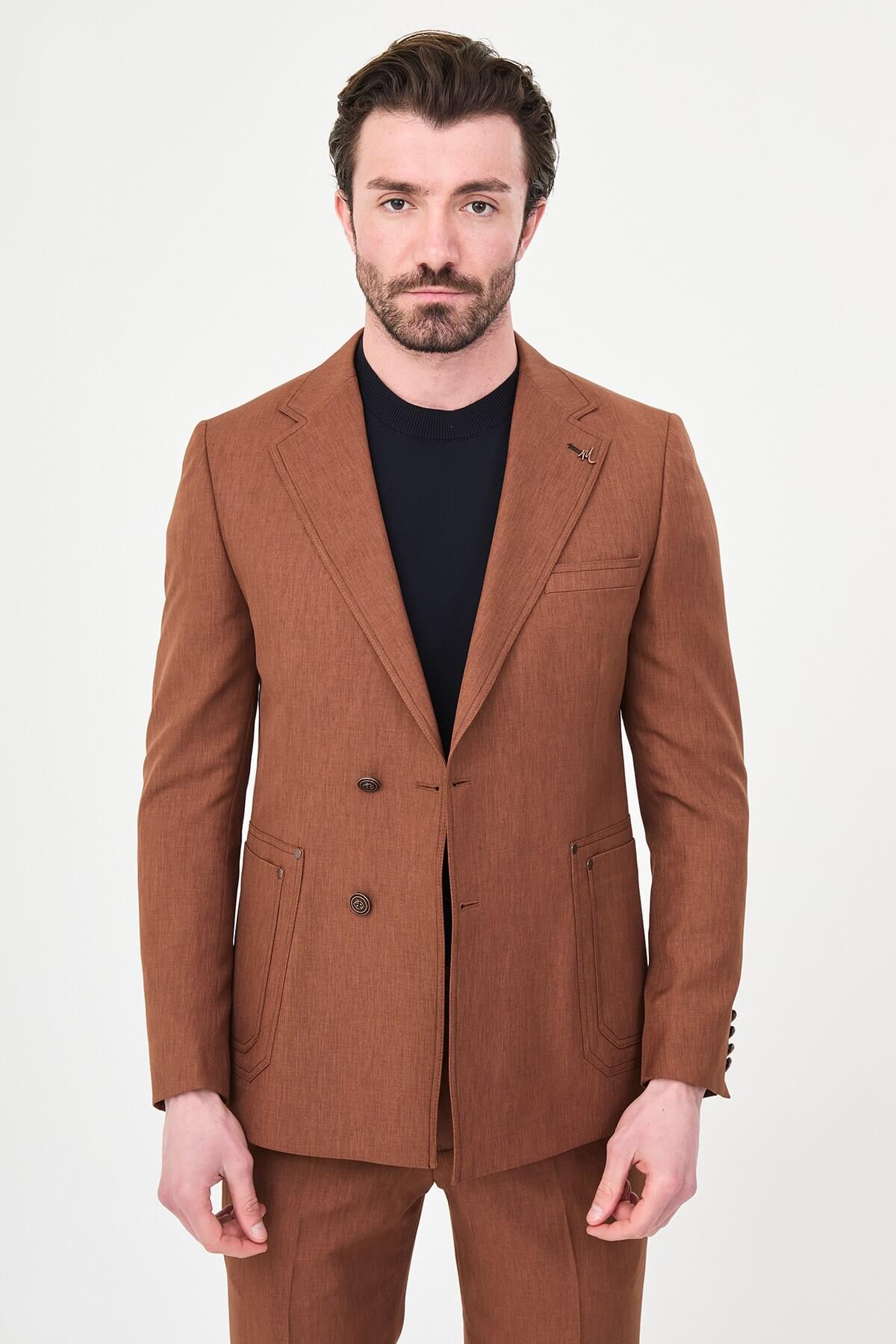 a tile slim-fit two-piece suit with notch lapels, utility-style stitched lower pockets, matching trousers, a black knit top, and brown leather shoes.