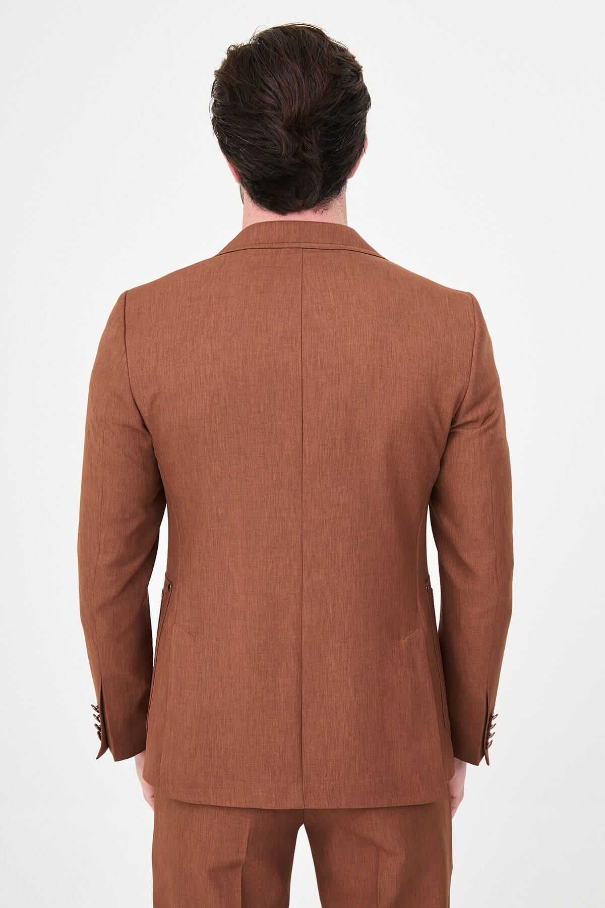 a tile slim-fit two-piece suit with notch lapels, utility-style stitched lower pockets, matching trousers, a black knit top, and brown leather shoes.