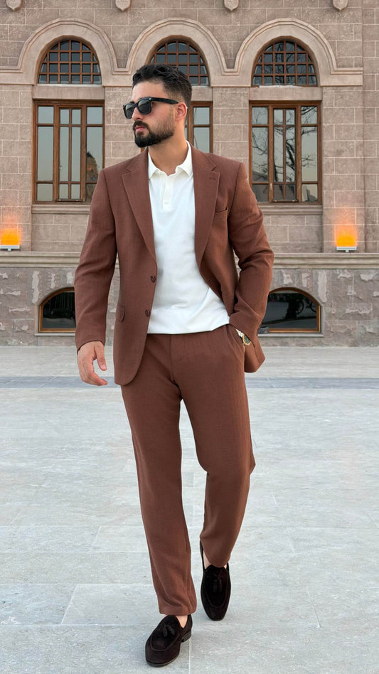 Men’s tile brown two piece suit with notch lapel jacket styled with white polo shirt and black loafers