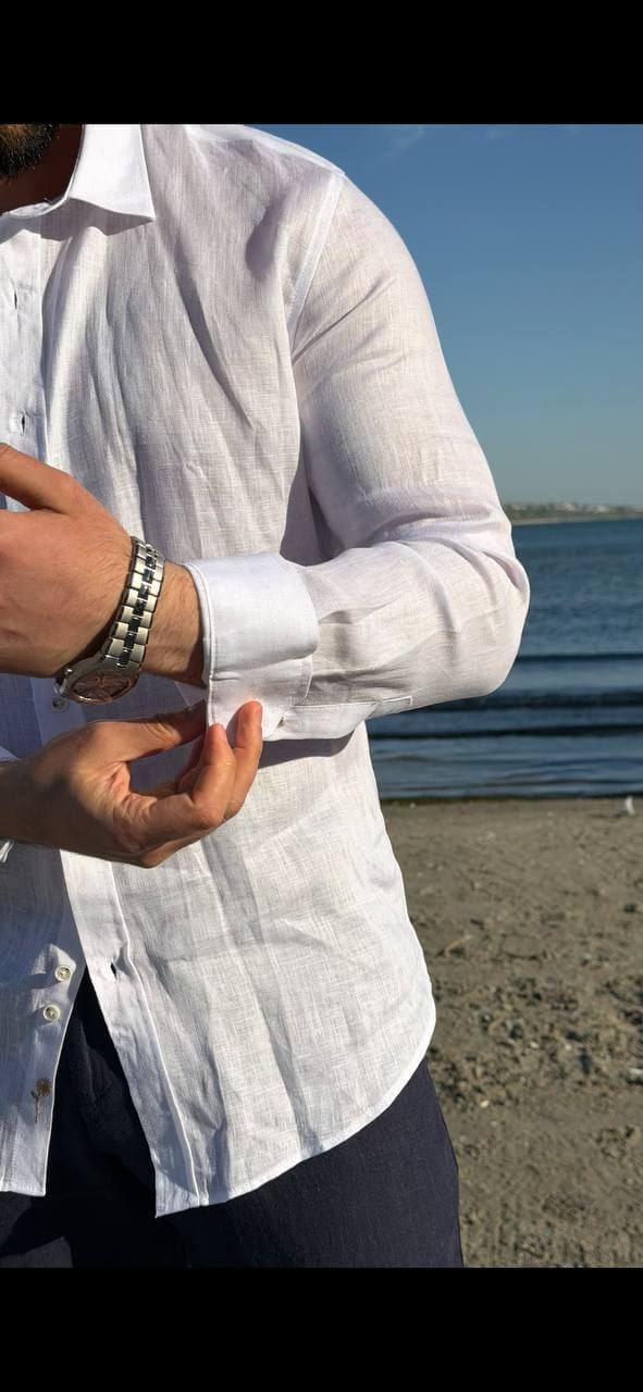 white linen collared dress shirt, standing by the water, sleeves rolled up, styled for summer.