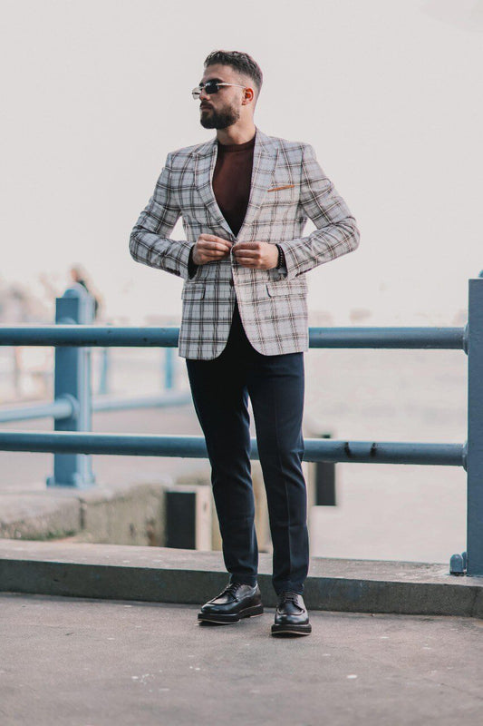 Men’s white plaid mono-collar slim-fit jacket styled with brown knit top and navy trousers