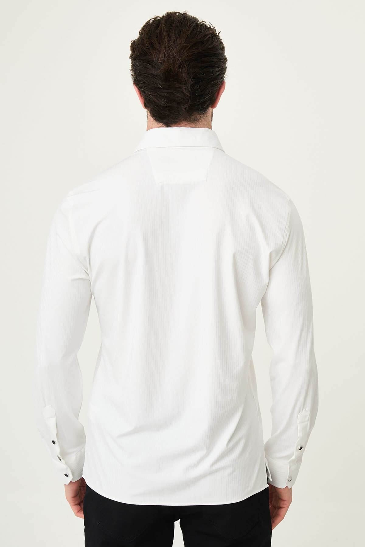 white slim-fit long sleeve shirt with subtle vertical stripes and a pocket detail, styled with black trousers