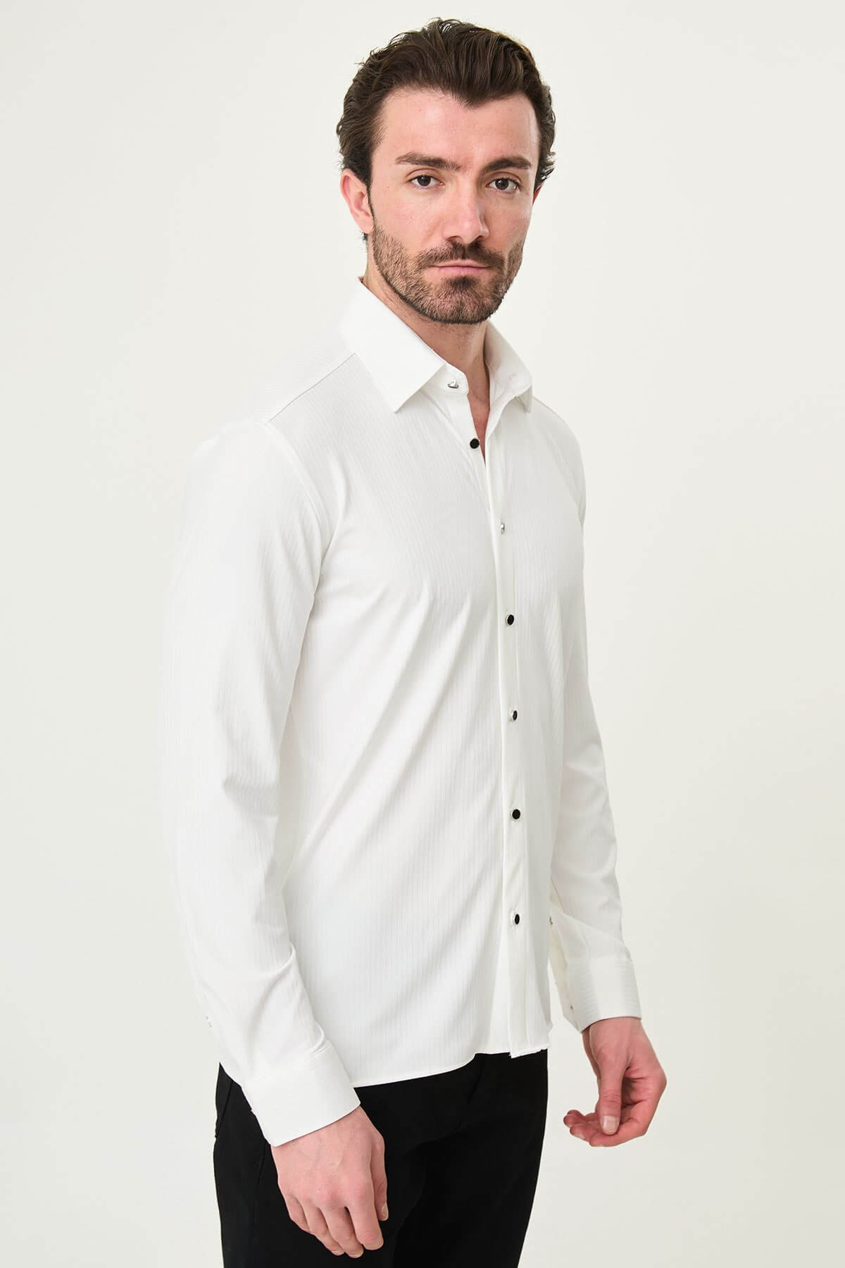 white slim-fit long sleeve shirt with subtle vertical stripes and a pocket detail, styled with black trousers
