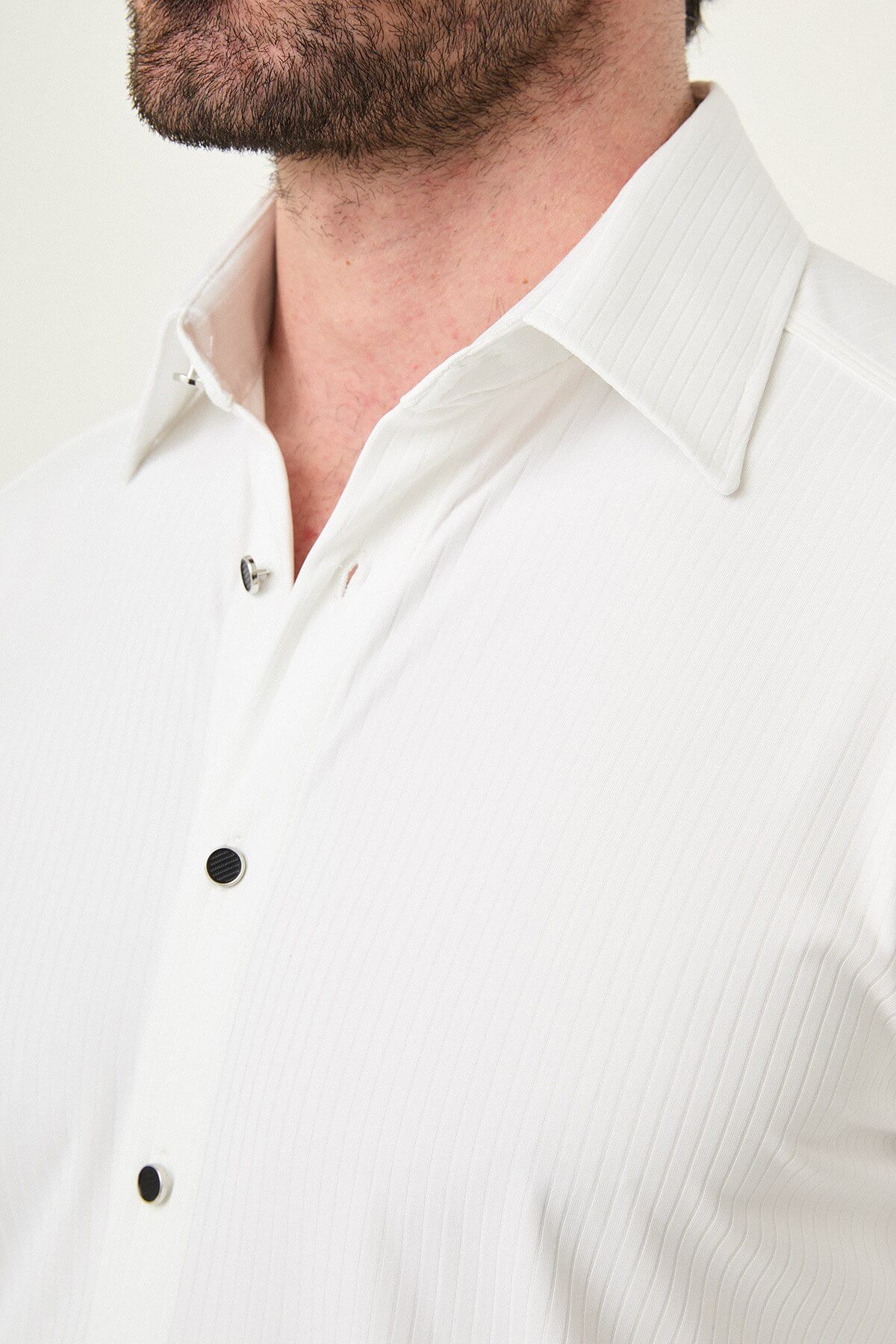 white slim-fit long sleeve shirt with subtle vertical stripes and a pocket detail, styled with black trousers