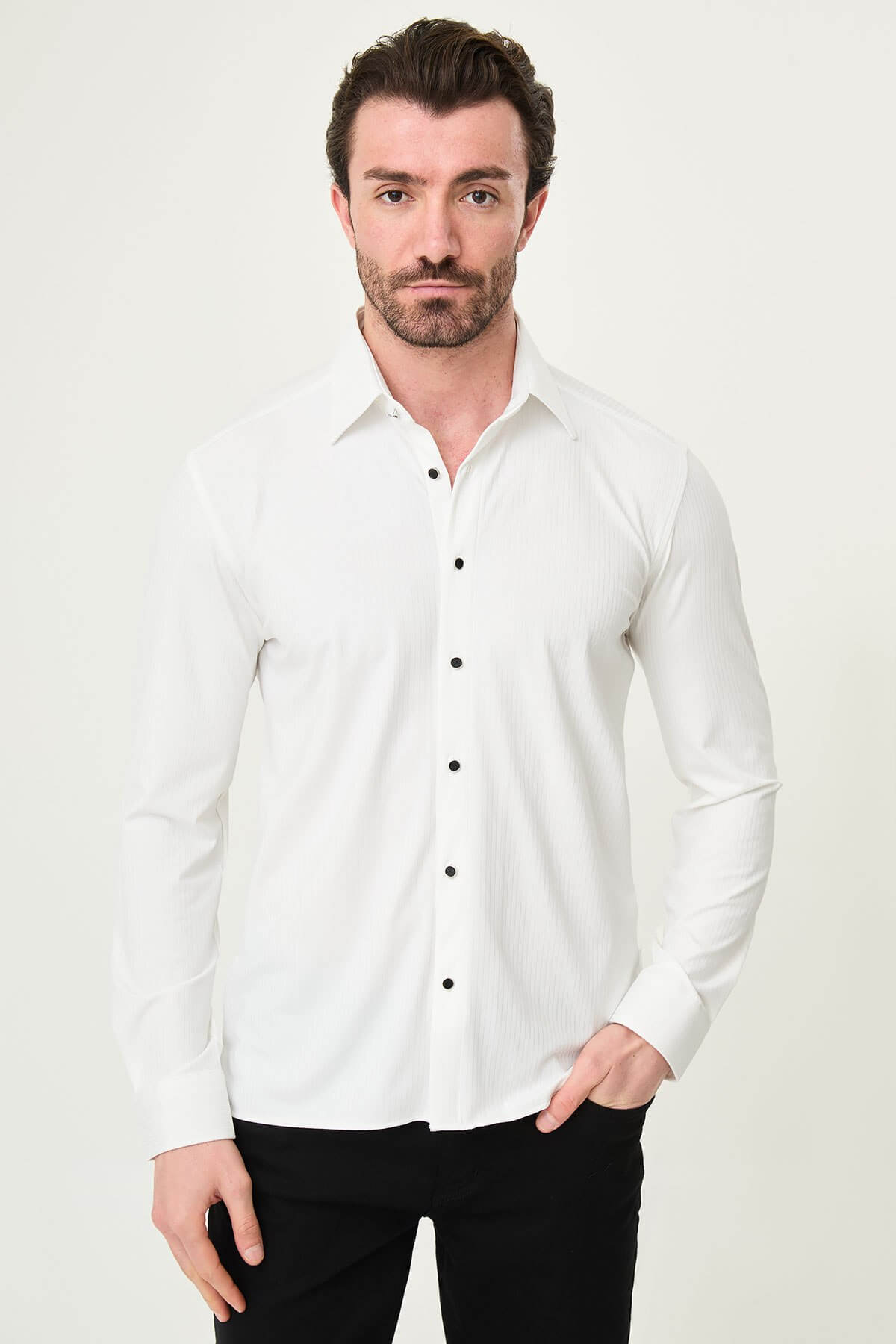 white slim-fit long sleeve shirt with subtle vertical stripes and a pocket detail, styled with black trousers