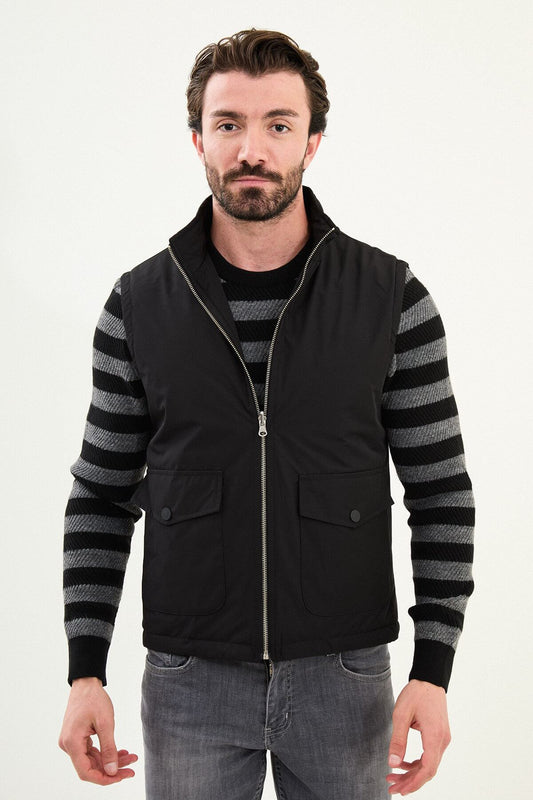 Men’s matte black technical vest with a stand collar and snap-flap utility pockets, designed for winter layering.