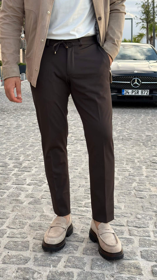 Men’s brown slim fit trousers with stretch fabric and drawstring waistband styled for fall winter fashion