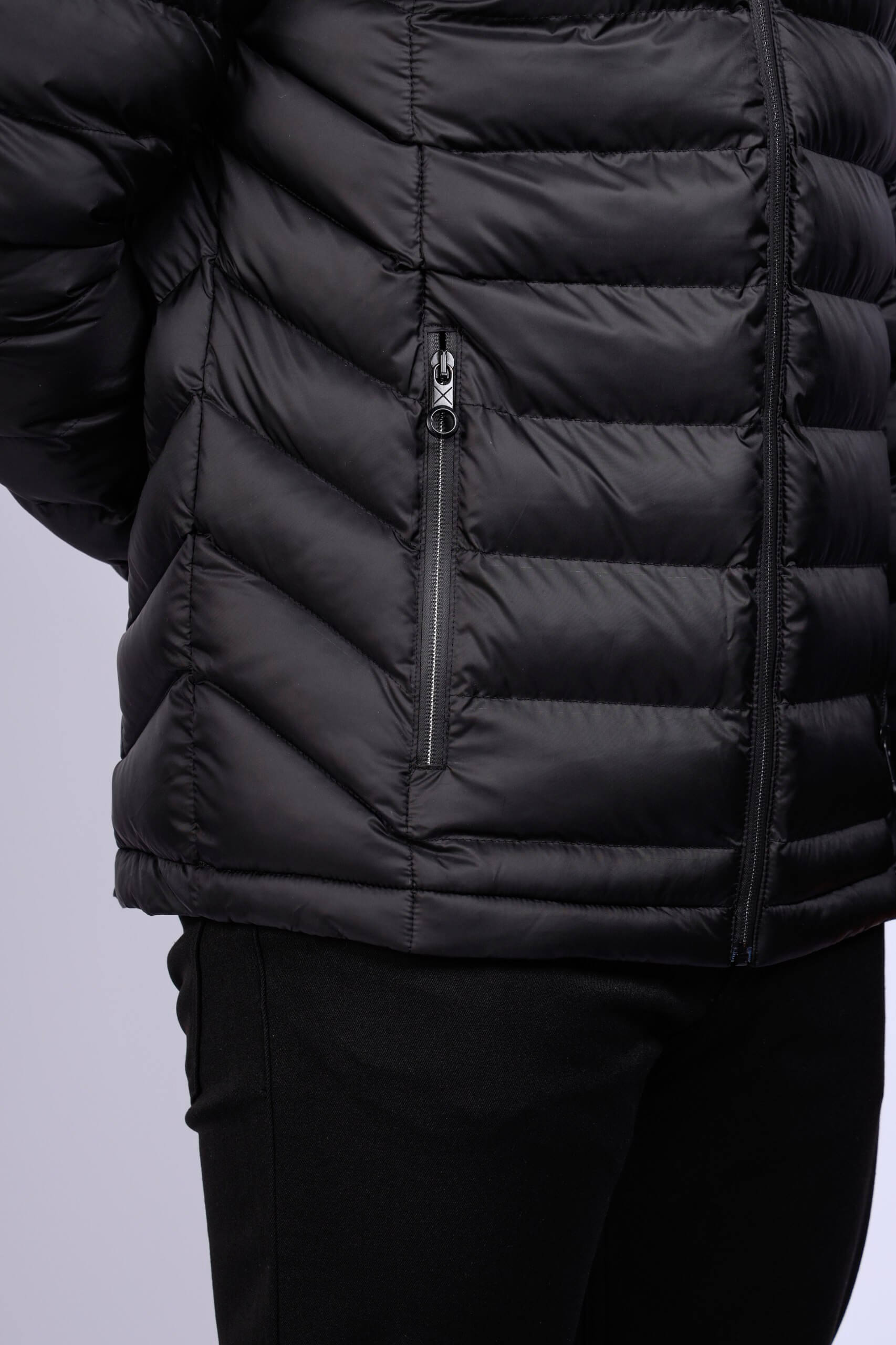 Men wearing a black quilted puffer jacket with zip closure and stand collar, lightweight insulated fall winter outerwear.