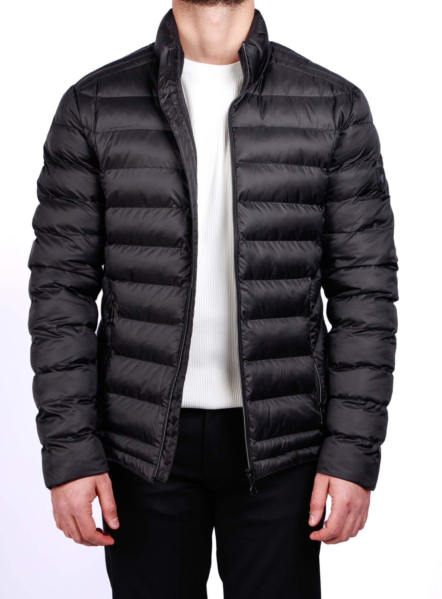 Men wearing a black quilted puffer jacket with zip closure and stand collar, lightweight insulated fall winter outerwear.