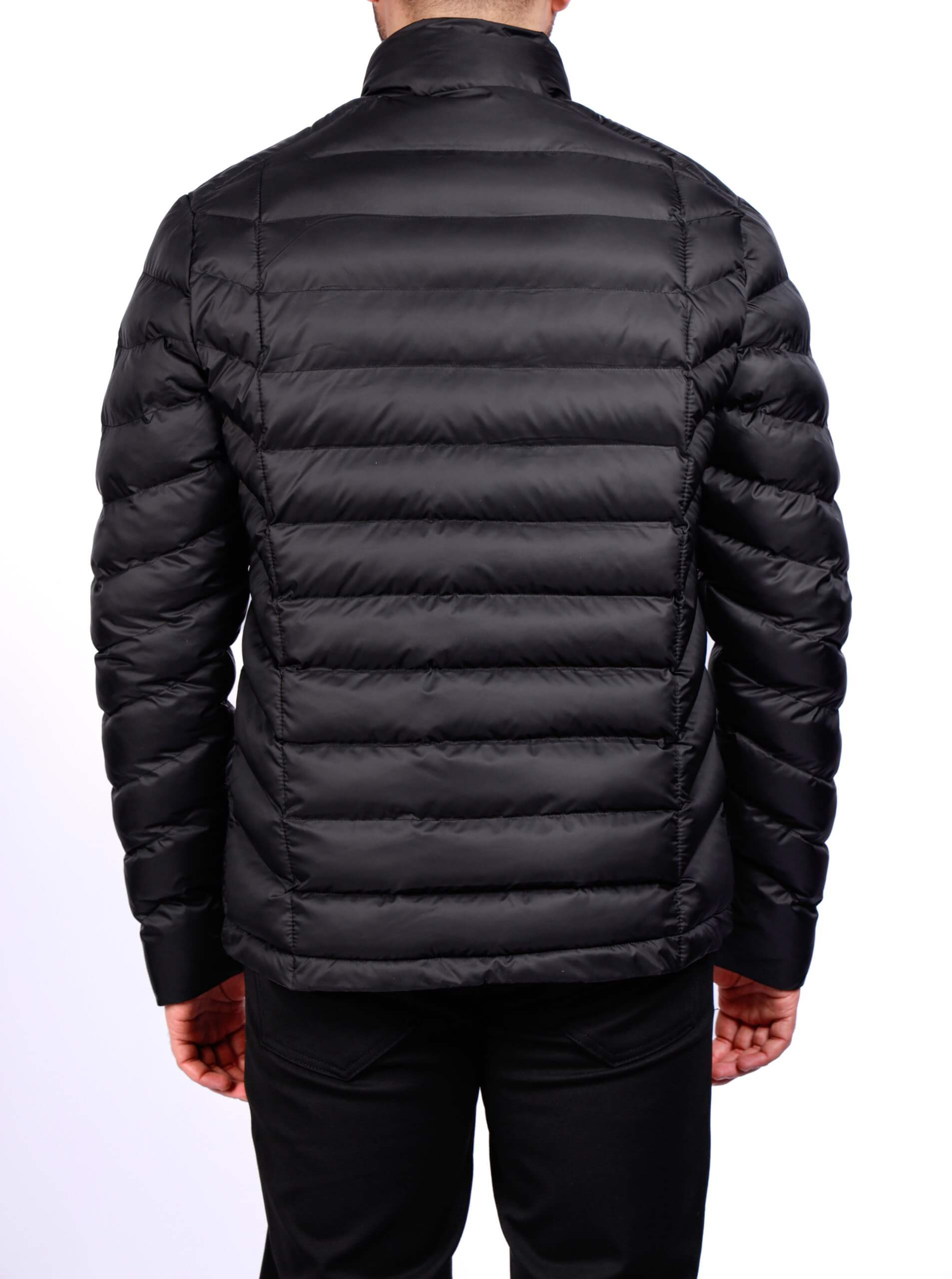 Men wearing a black quilted puffer jacket with zip closure and stand collar, lightweight insulated fall winter outerwear.