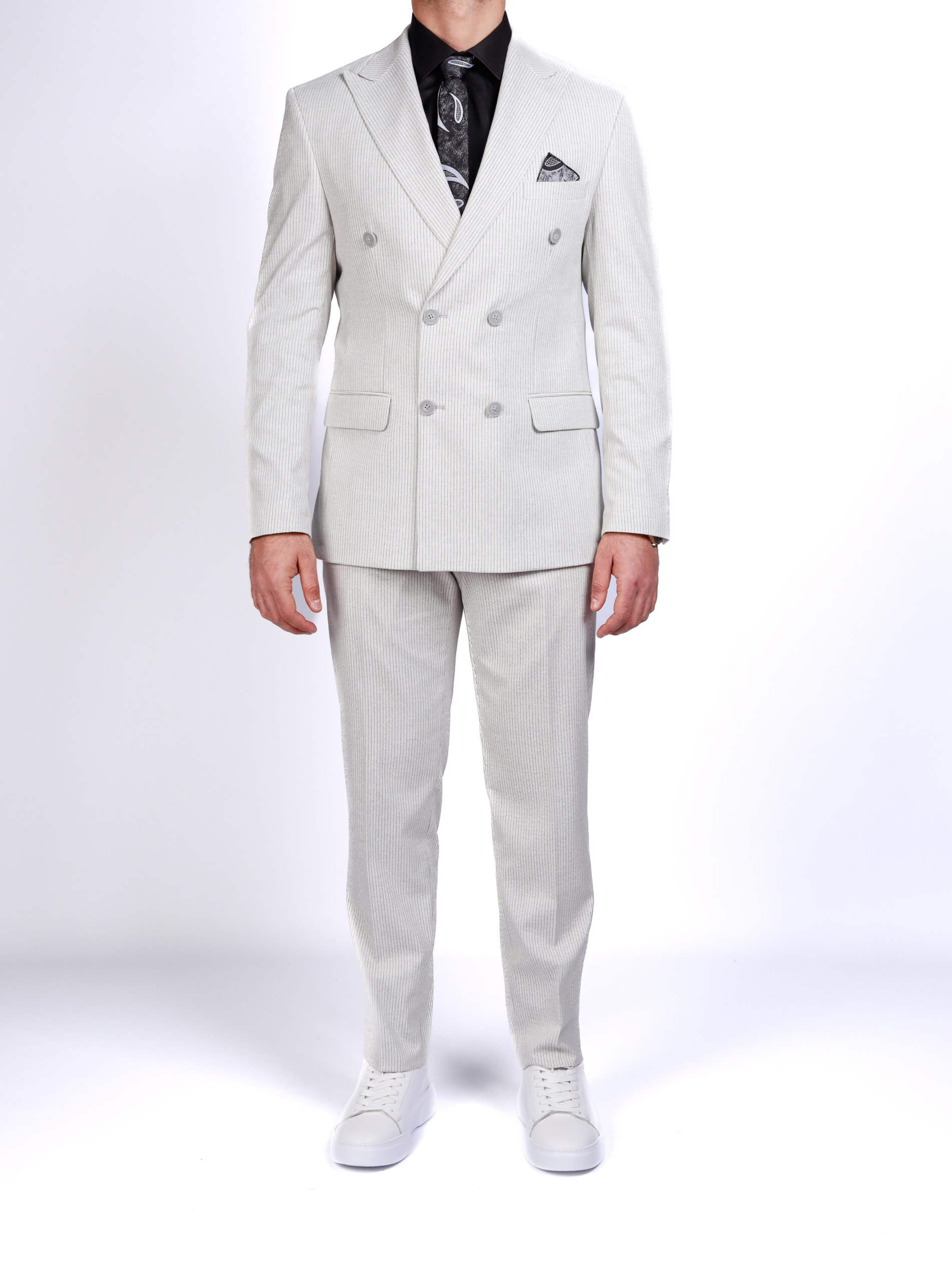 Men wearing a gray double-breasted pinstripe suit with peak lapels, tailored fit trousers, white sneakers, and black shirt