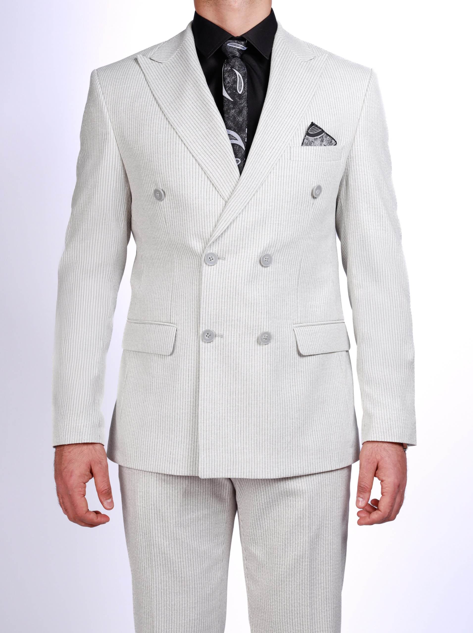 Men wearing a gray double-breasted pinstripe suit with peak lapels, tailored fit trousers, white sneakers, and black shirt