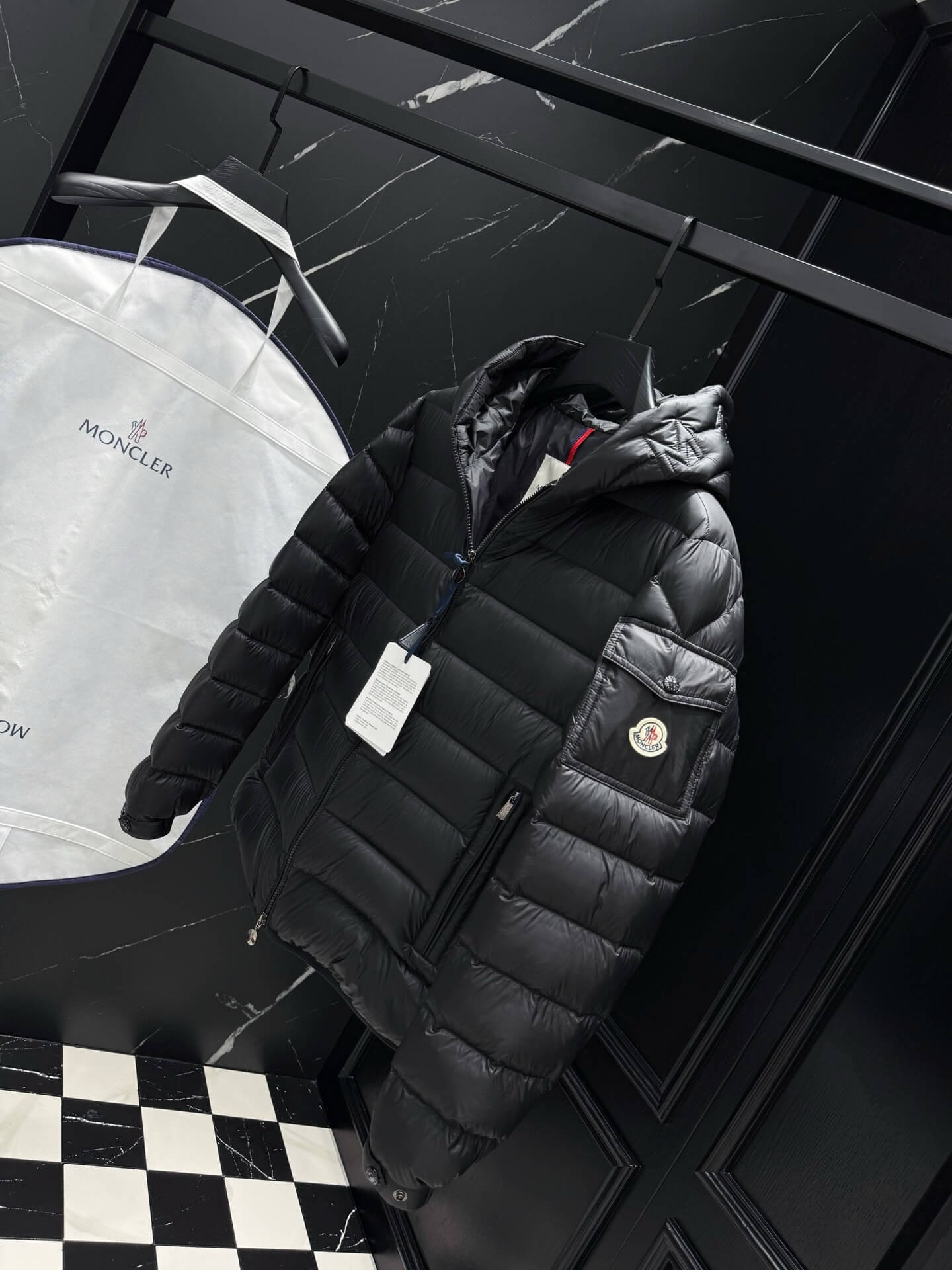 Black shiny down puffer jacket with hood, front zipper, and quilted padding, Moncler-inspired design.