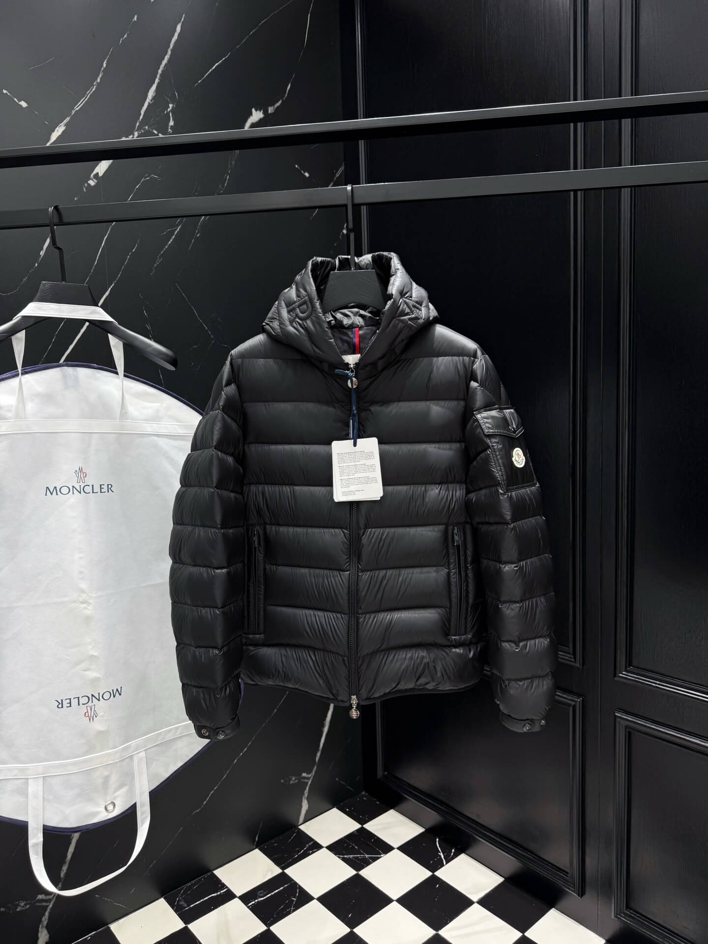 Black shiny down puffer jacket with hood, front zipper, and quilted padding, Moncler-inspired design.