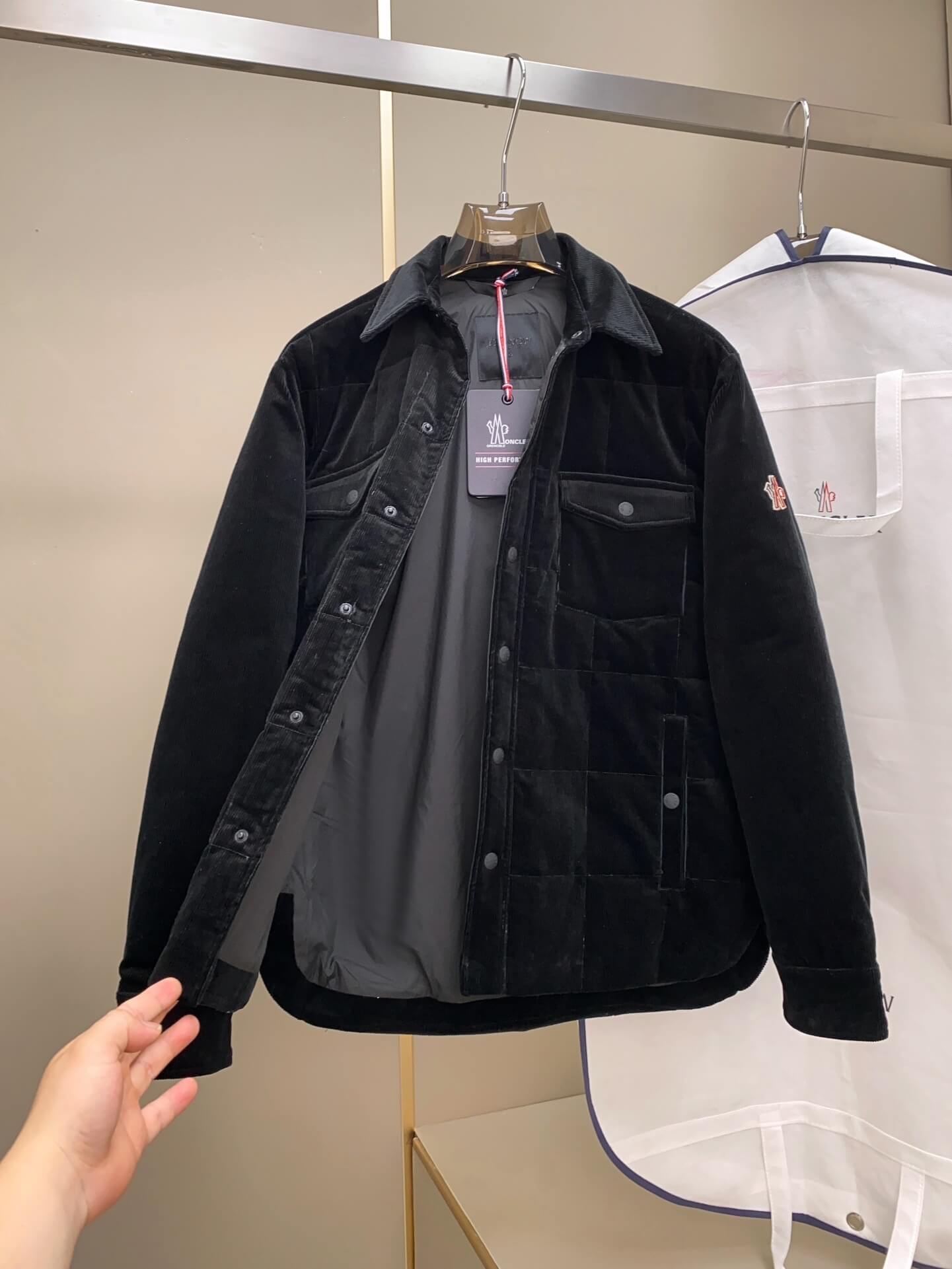 Black corduroy down shirt jacket with quilted paneling, button closure, and chest pockets, Moncler-inspired design.