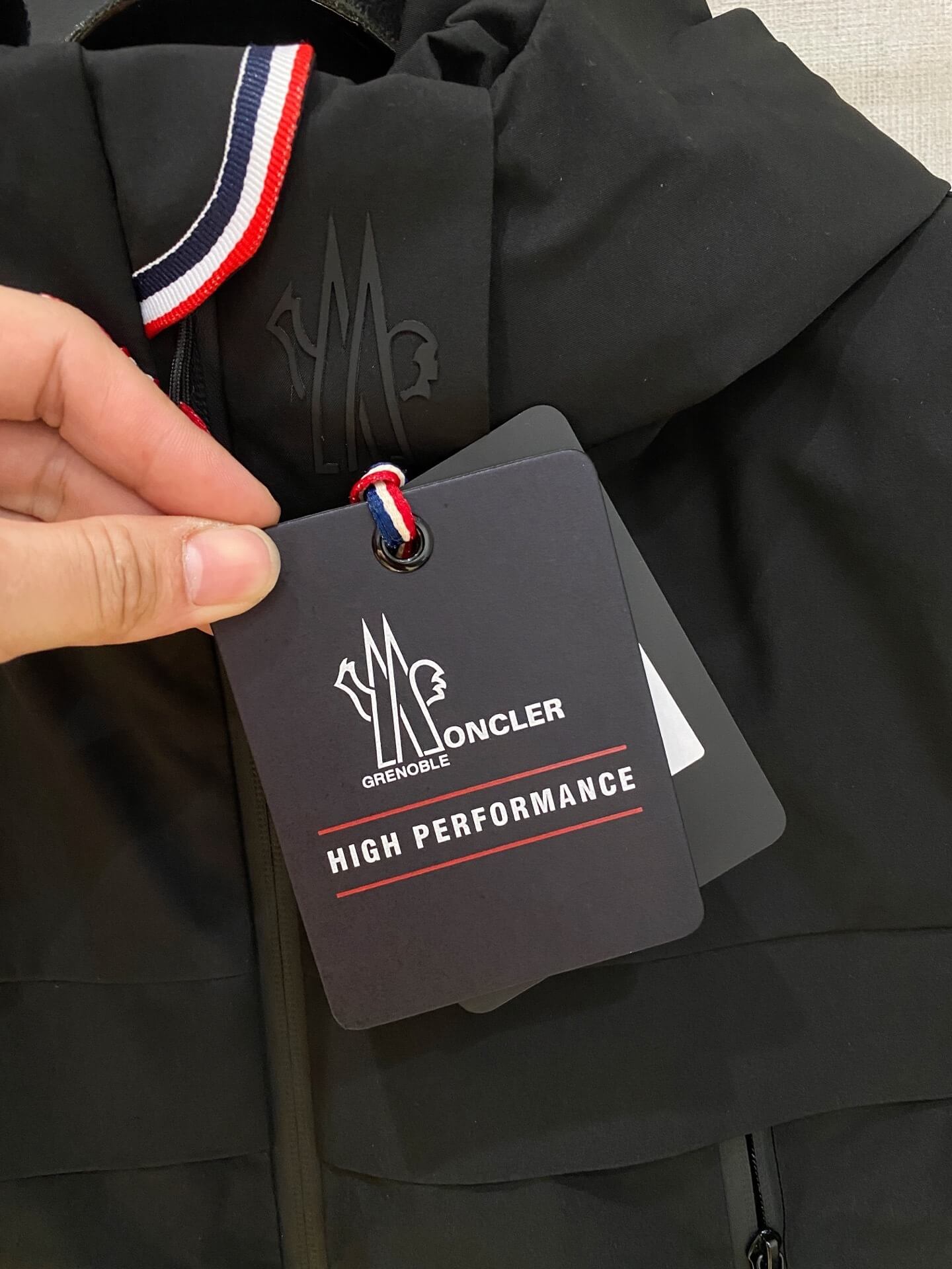 Black hooded down jacket with zip pockets and technical shell, Moncler Grenoble Balmhorn-inspired design.