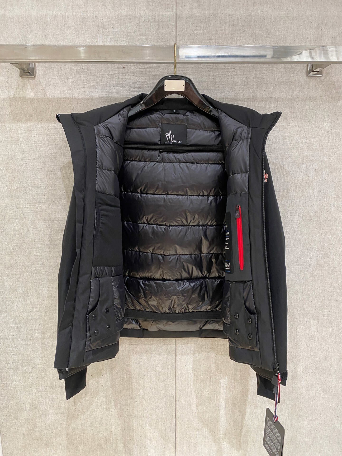 Black hooded down jacket with zip pockets and technical shell, Moncler Grenoble Balmhorn-inspired design.