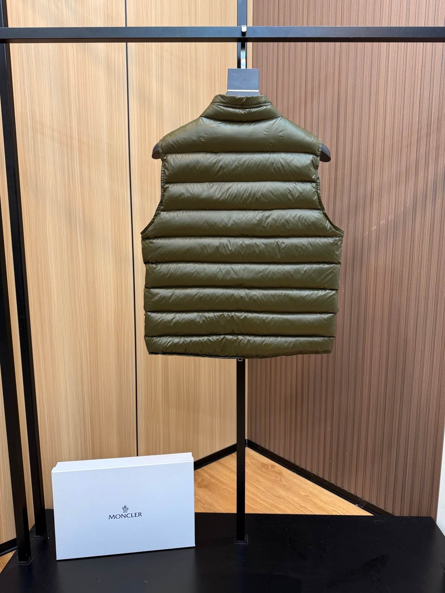 Green glossy down vest with chest logo patch and zippered pockets, Moncler Gui-inspired design.