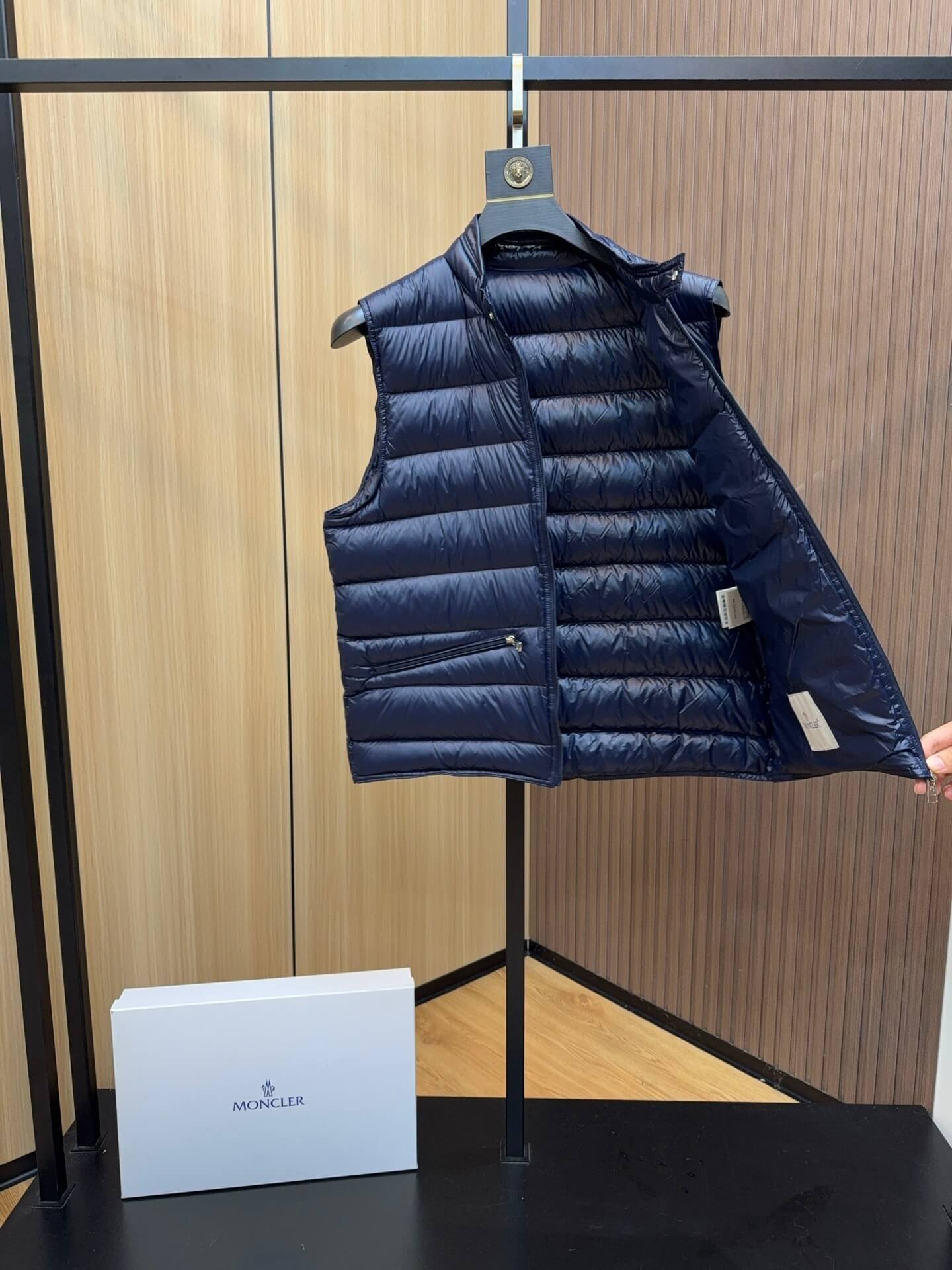 Navy blue glossy down vest with chest logo patch and zippered pockets, Moncler Gui-inspired.