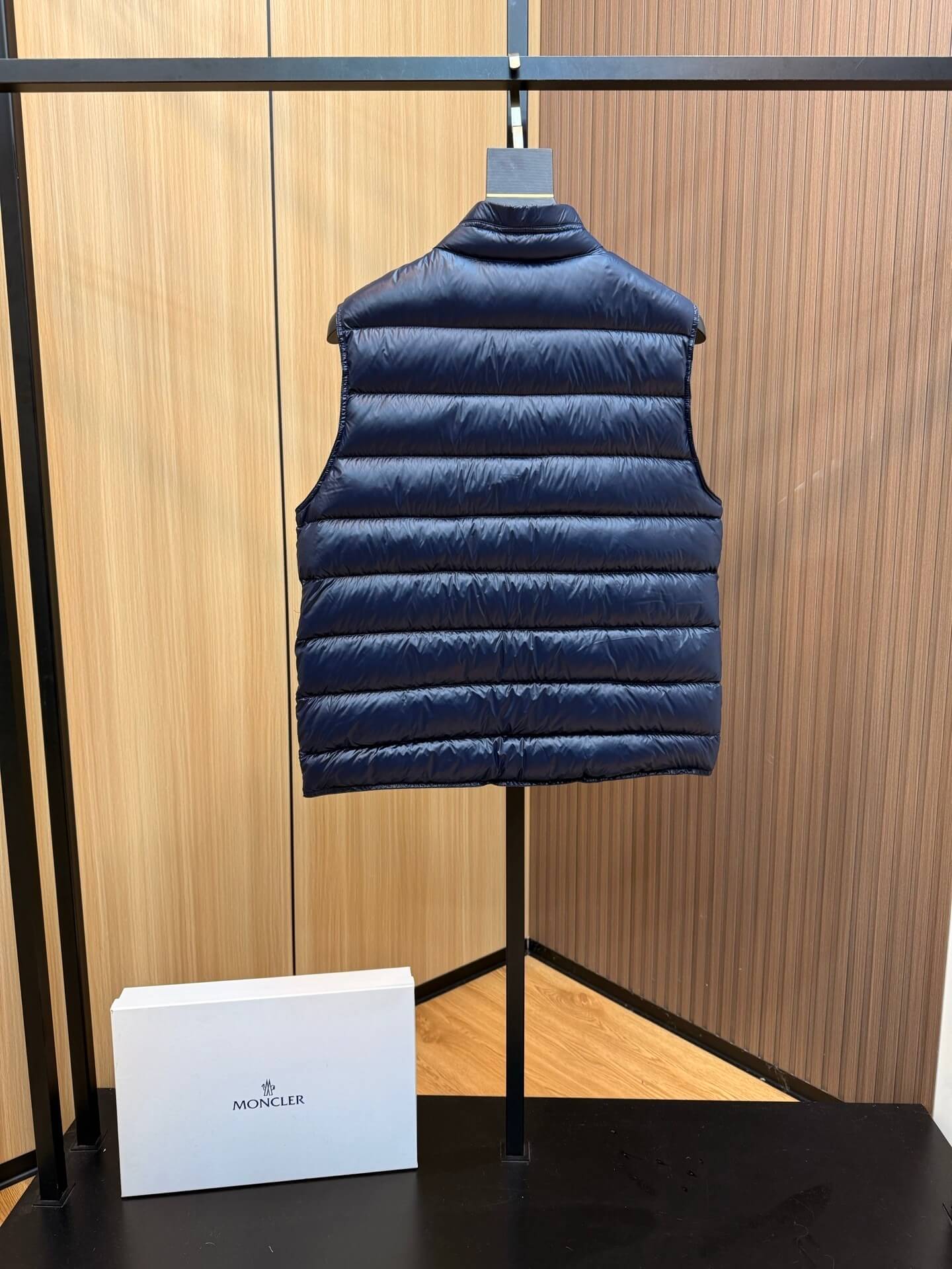 Navy blue glossy down vest with chest logo patch and zippered pockets, Moncler Gui-inspired.