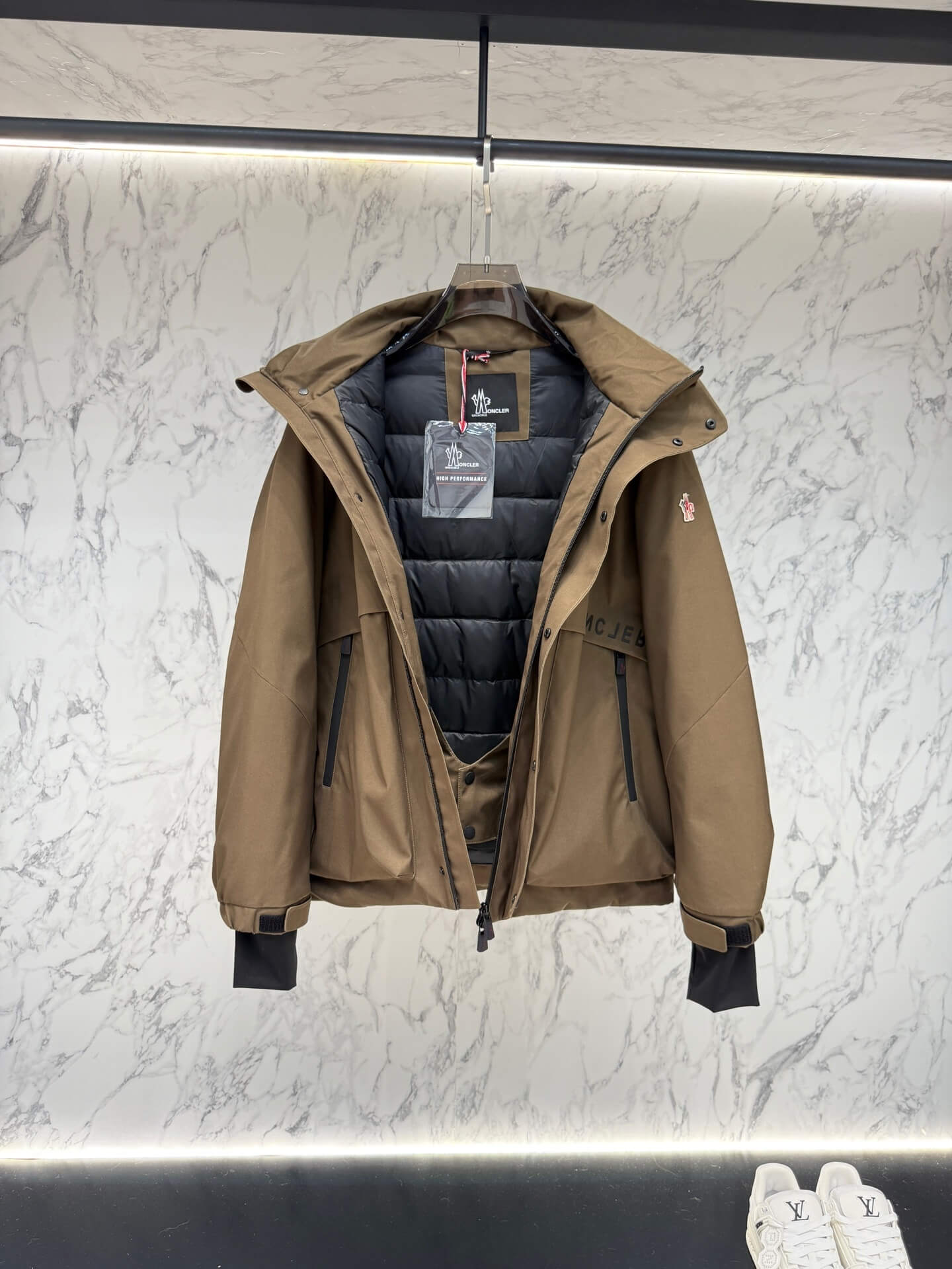 Brown hooded technical jacket with front snap closure and zippered pockets, Moncler-inspired design