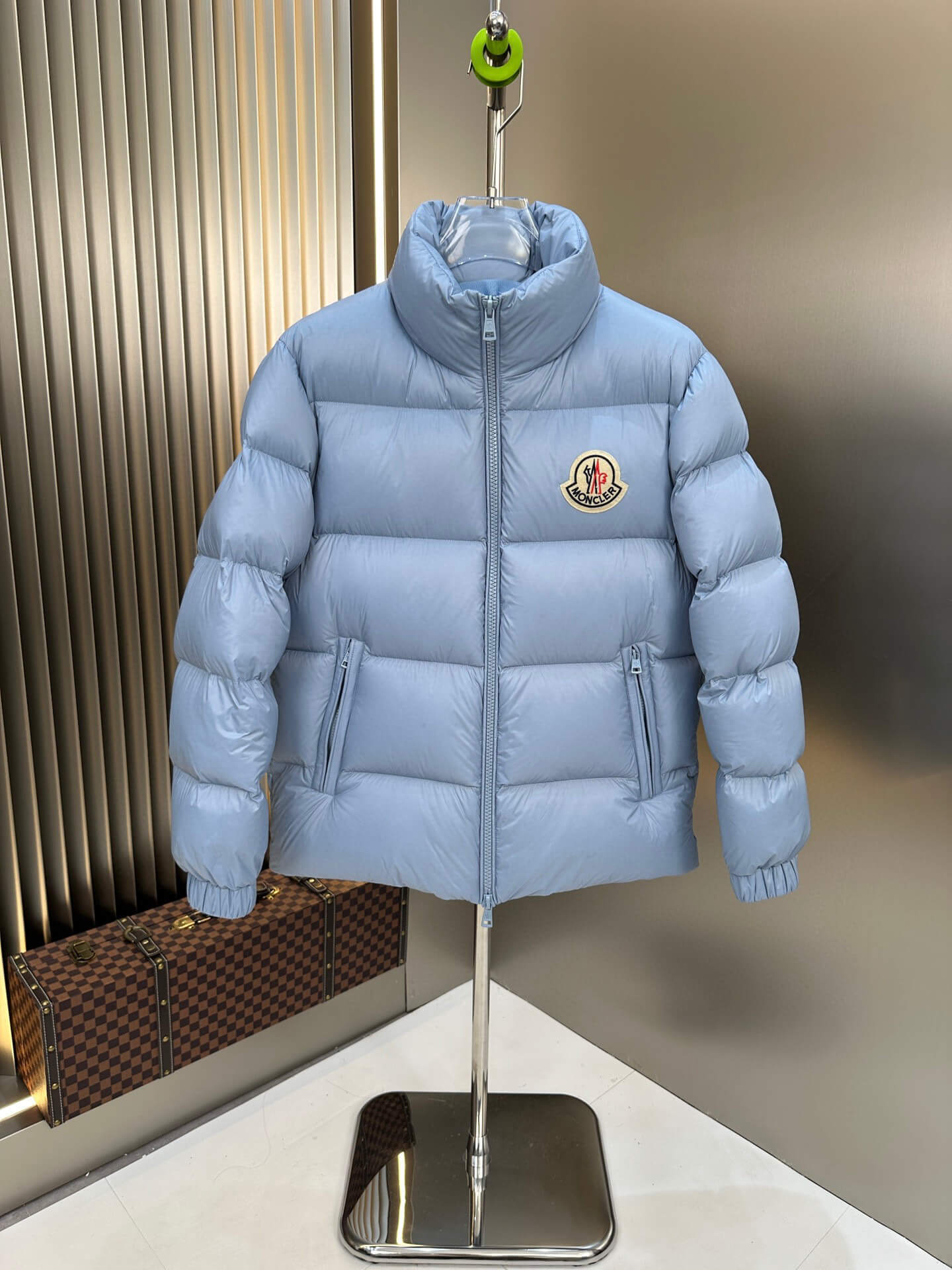 Moncler Maya Blue Hooded Short Down Jacket featuring a sky-blue quilted design, front zip closure, and Moncler logo patch on the chest.
