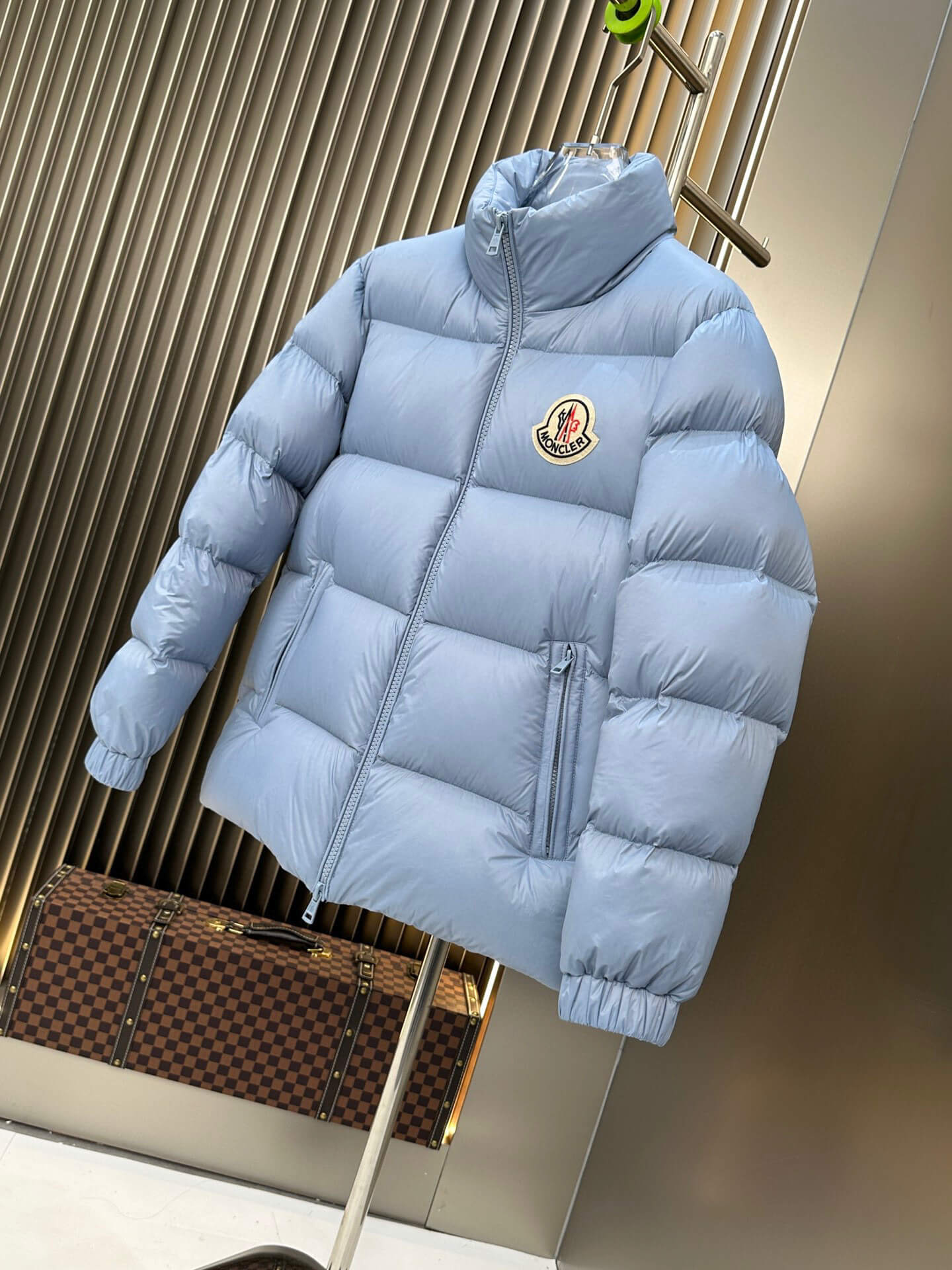 Moncler Maya Blue Hooded Short Down Jacket featuring a sky-blue quilted design, front zip closure, and Moncler logo patch on the chest.
