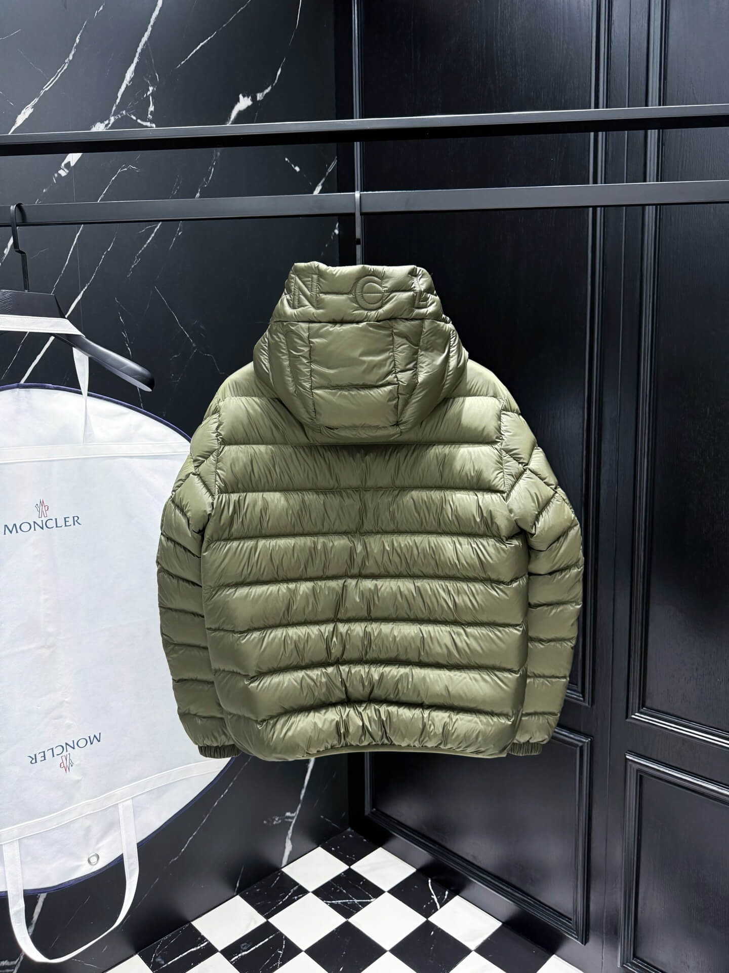 Green hooded glossy down jacket with quilted panels and zippered pockets, Moncler Maya-inspired design.