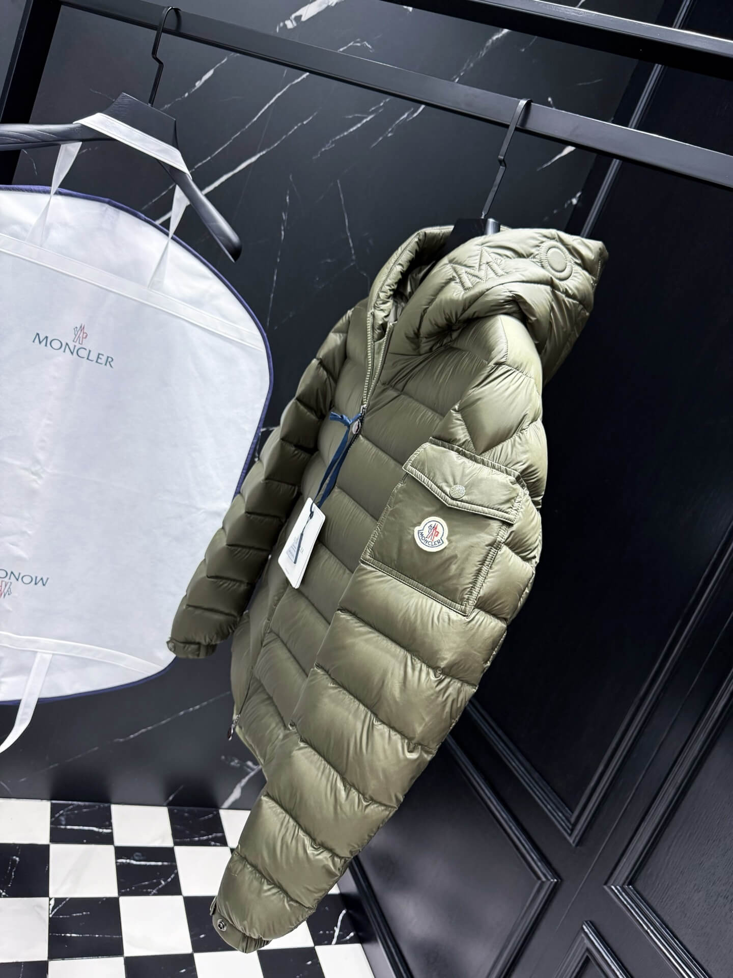 Green hooded glossy down jacket with quilted panels and zippered pockets, Moncler Maya-inspired design.