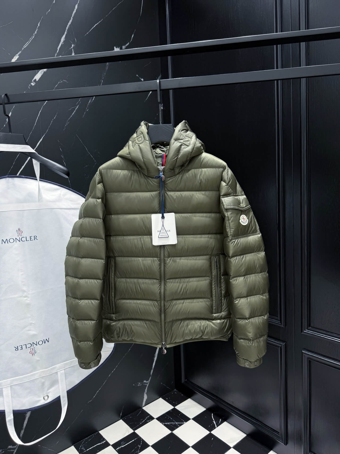 Green hooded glossy down jacket with quilted panels and zippered pockets, Moncler Maya-inspired design.