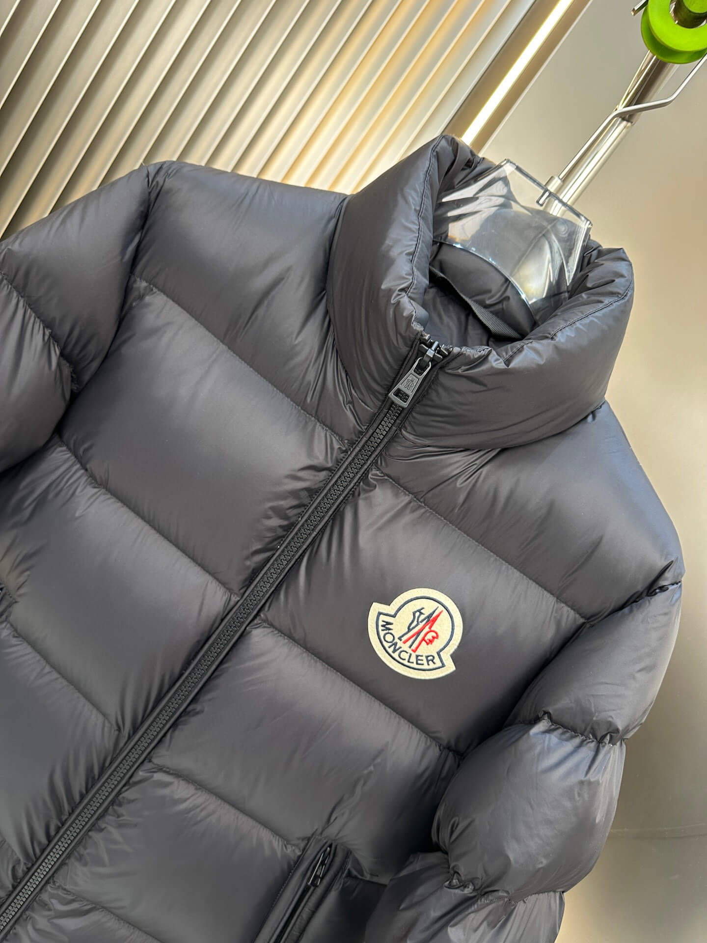 Black shiny down puffer jacket with hood and high collar, Moncler-inspired design, front view on mannequin.