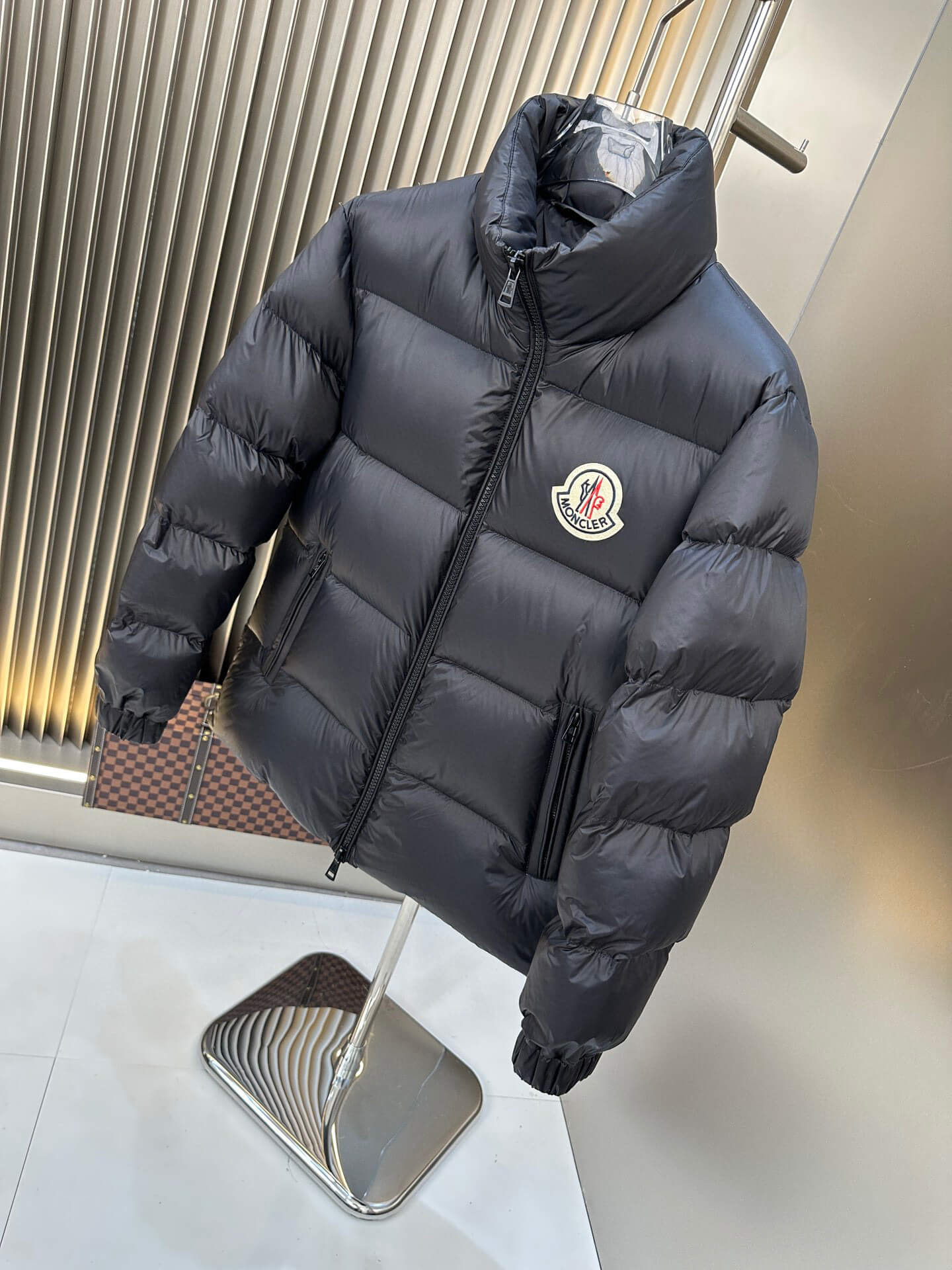 Black shiny down puffer jacket with hood and high collar, Moncler-inspired design, front view on mannequin.