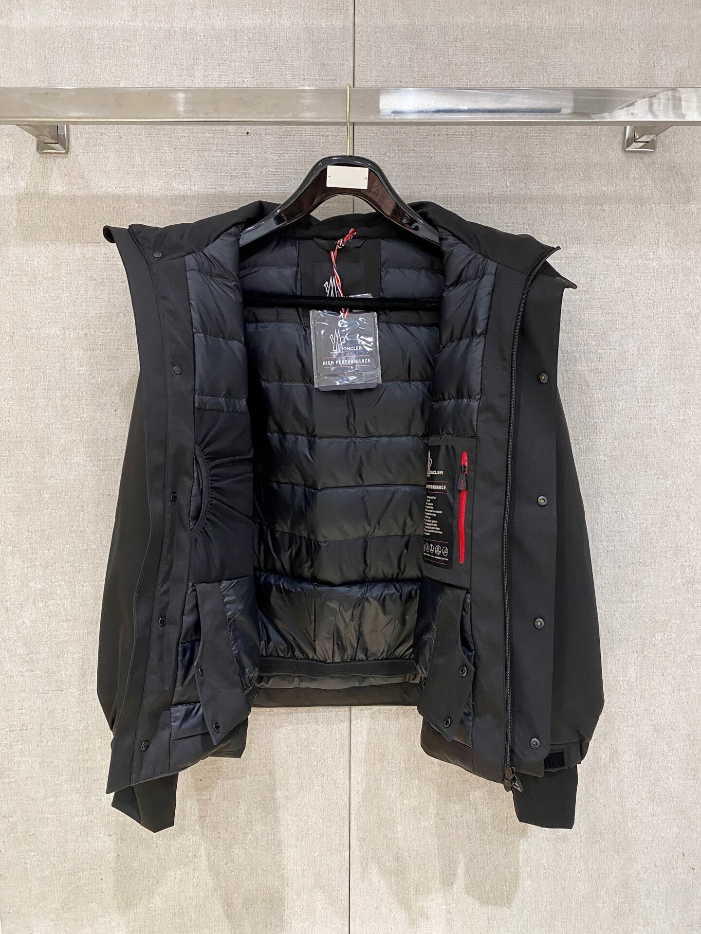 Black Moncler-inspired men’s Maya down jacket with quilted puffer design, detachable hood, and front zip closure, displayed on hanger.