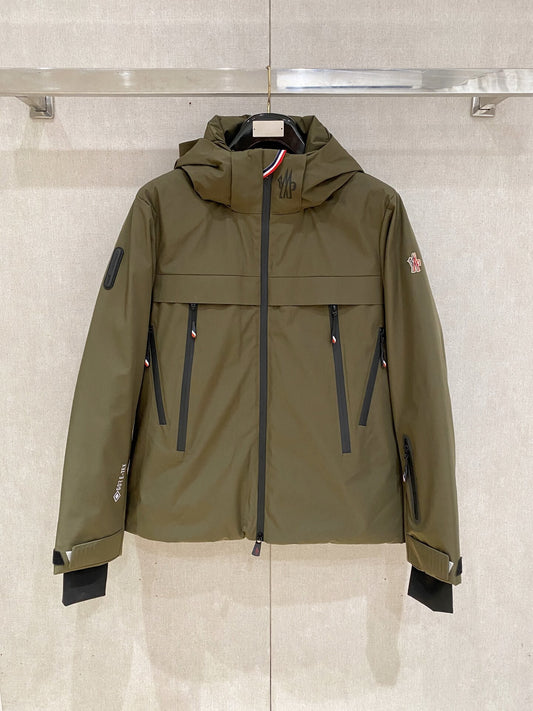 Olive-green hooded technical down jacket, unzipped to show black quilted lining and snow-skirt; Moncler-inspired design