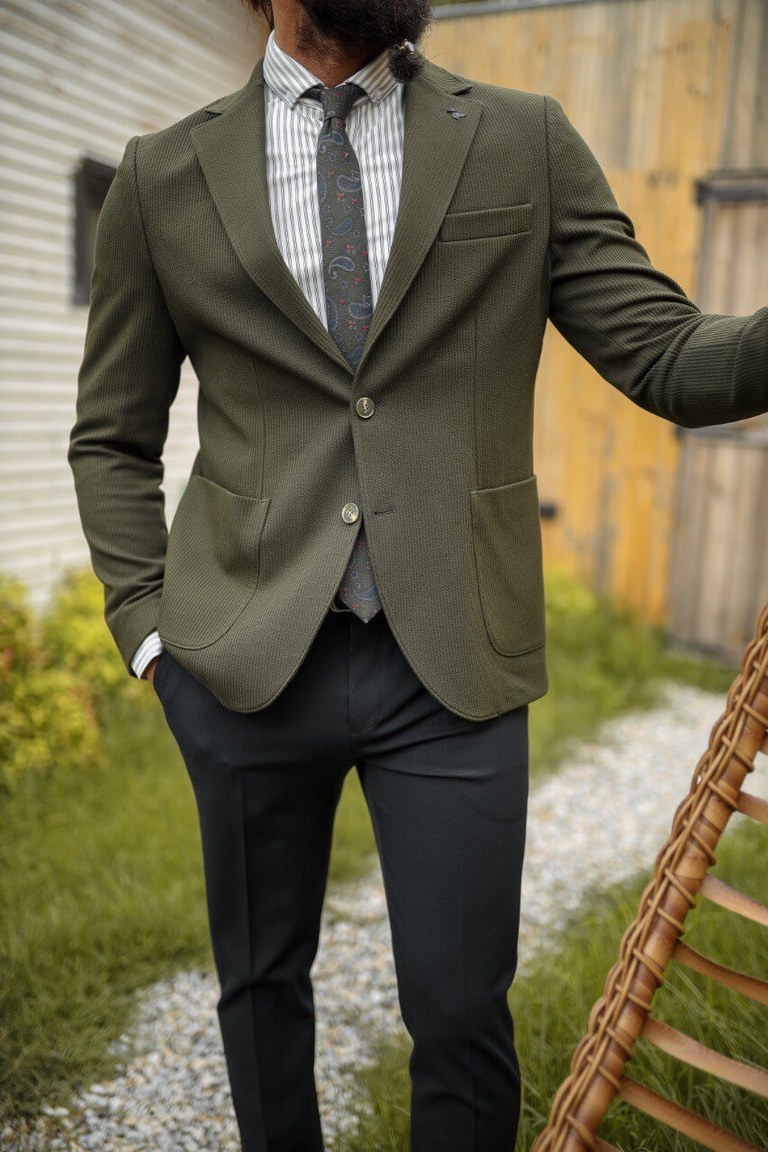 Olive green textured blazer with mono collar and pocket details paired with black slim-fit trousers, styled as a modern men’s combination suit.