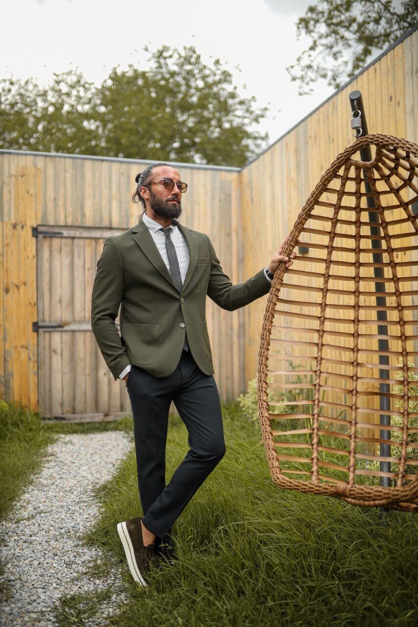 Olive green textured blazer with mono collar and pocket details paired with black slim-fit trousers, styled as a modern men’s combination suit.