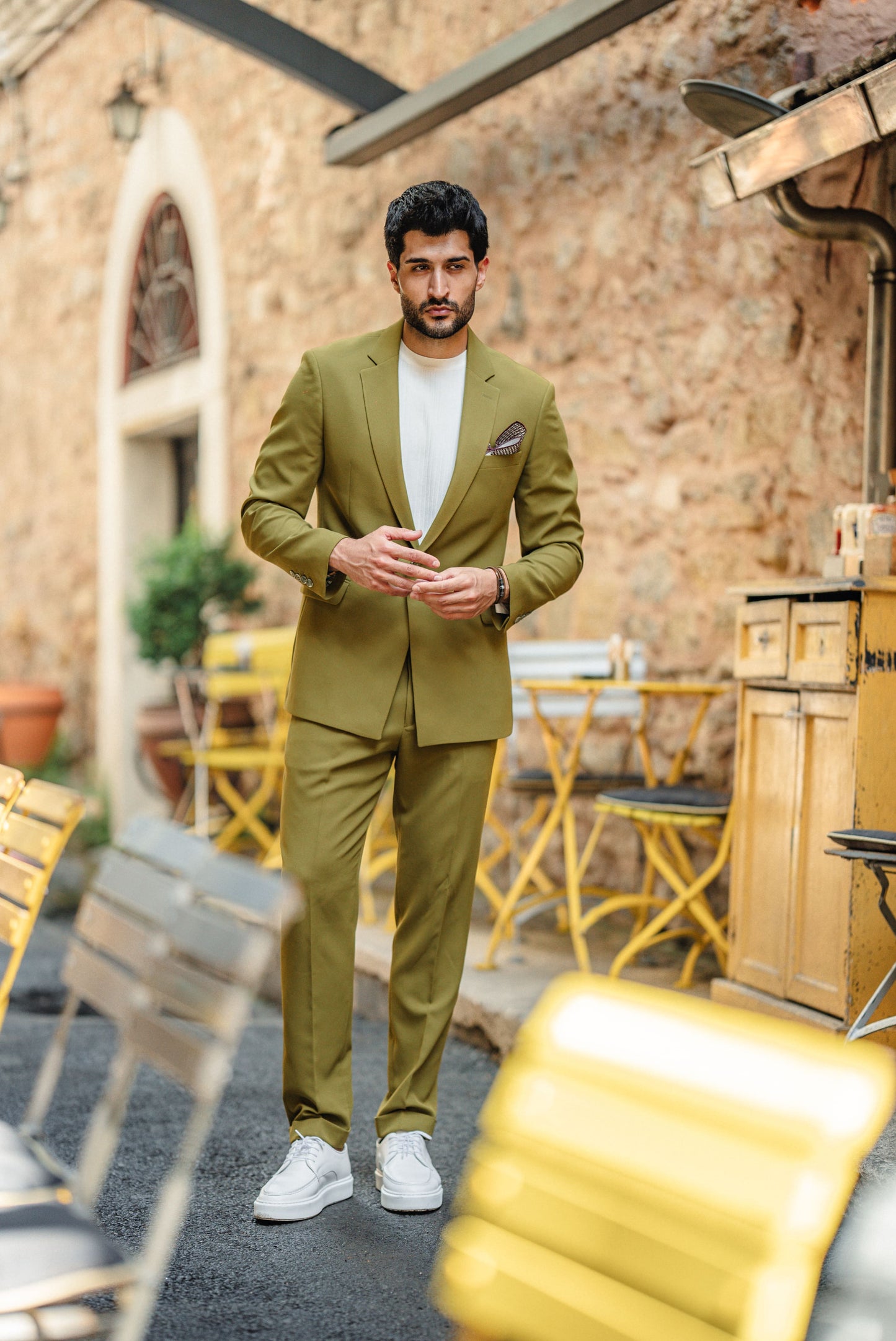 Man wearing the Bora Bora Olive Green Luxury Chain Detailed Suit with a white shirt and loafers, styled against a tropical summer backdrop.