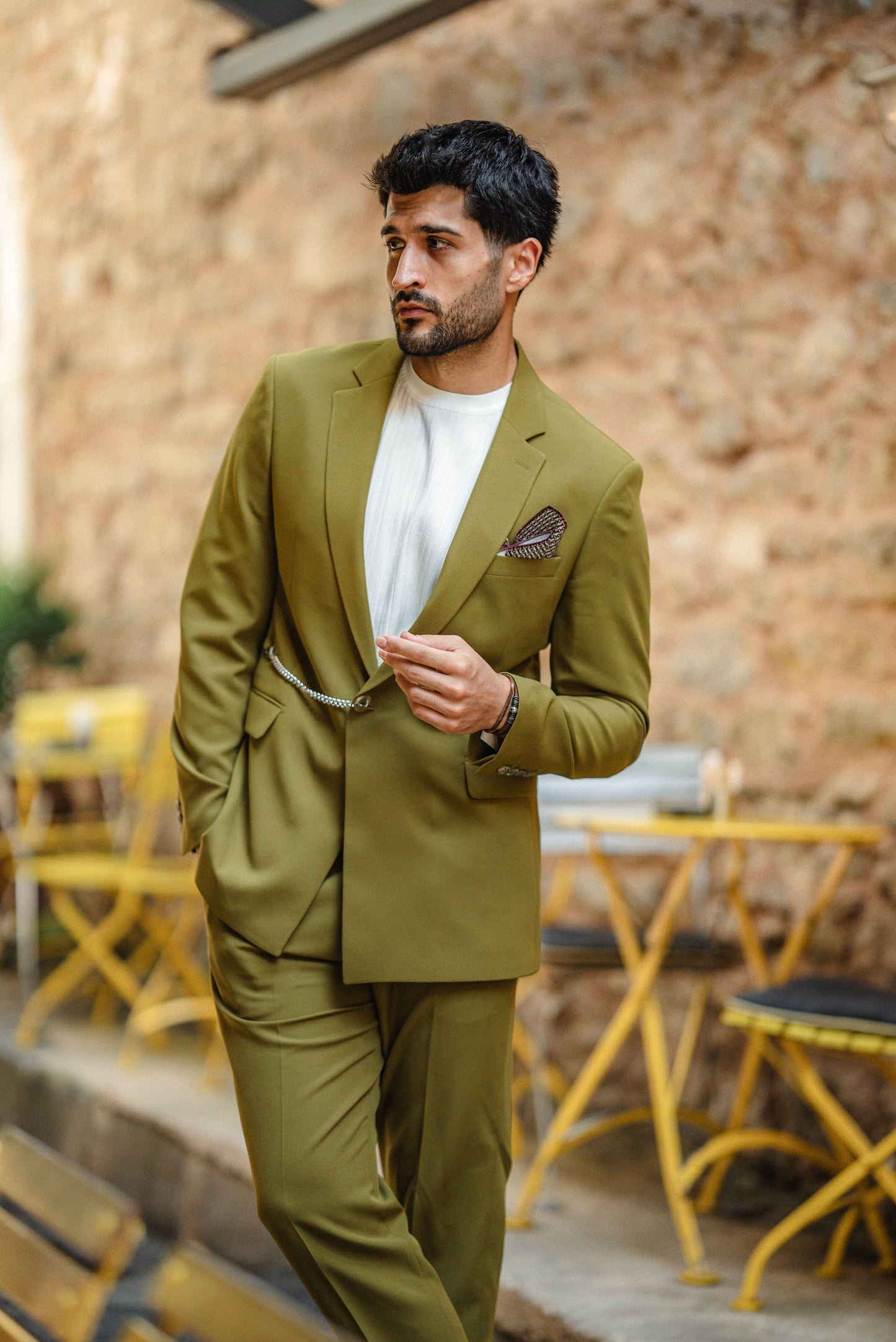 Man wearing the Bora Bora Olive Green Luxury Chain Detailed Suit with a white shirt and loafers, styled against a tropical summer backdrop.