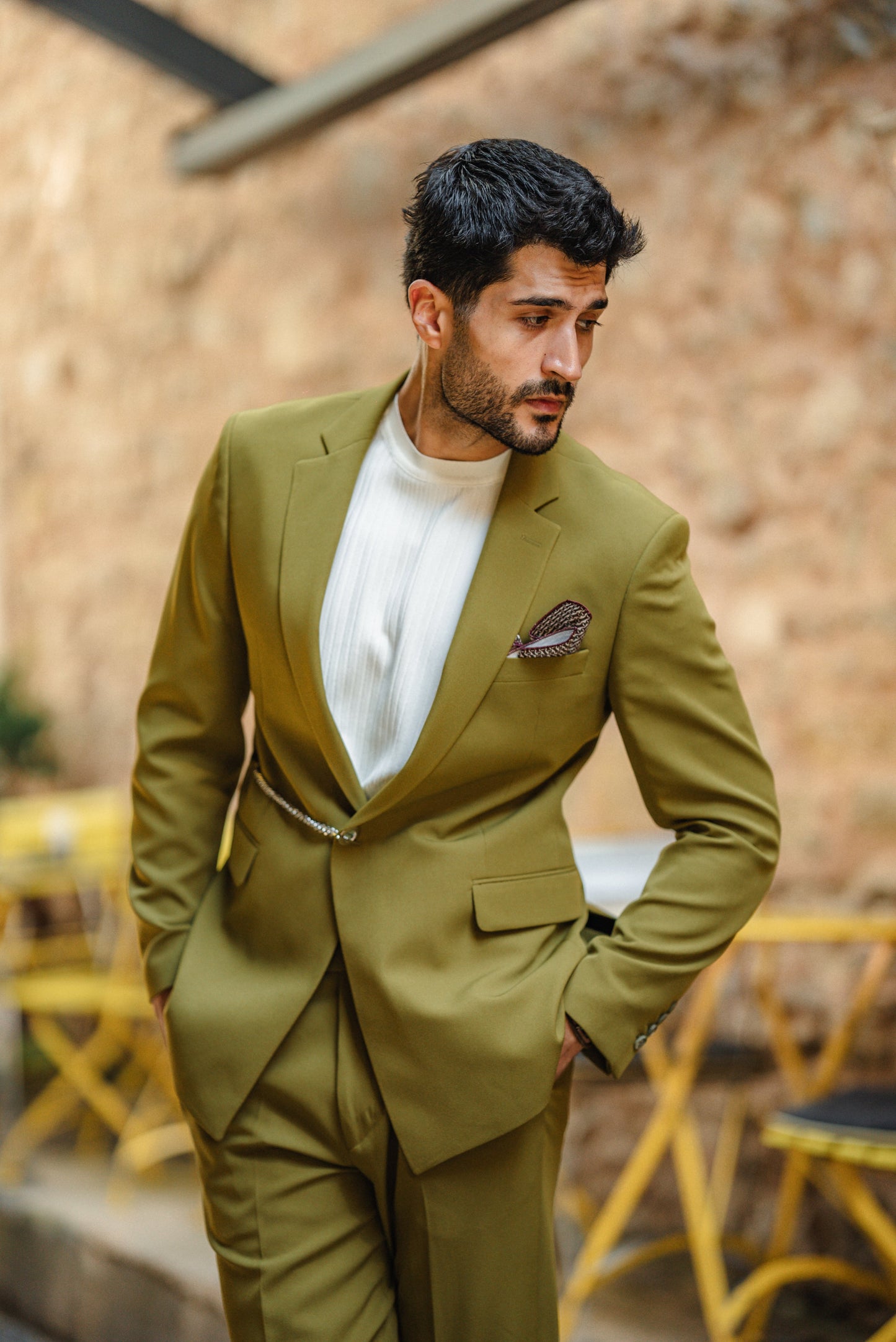 Man wearing the Bora Bora Olive Green Luxury Chain Detailed Suit with a white shirt and loafers, styled against a tropical summer backdrop.