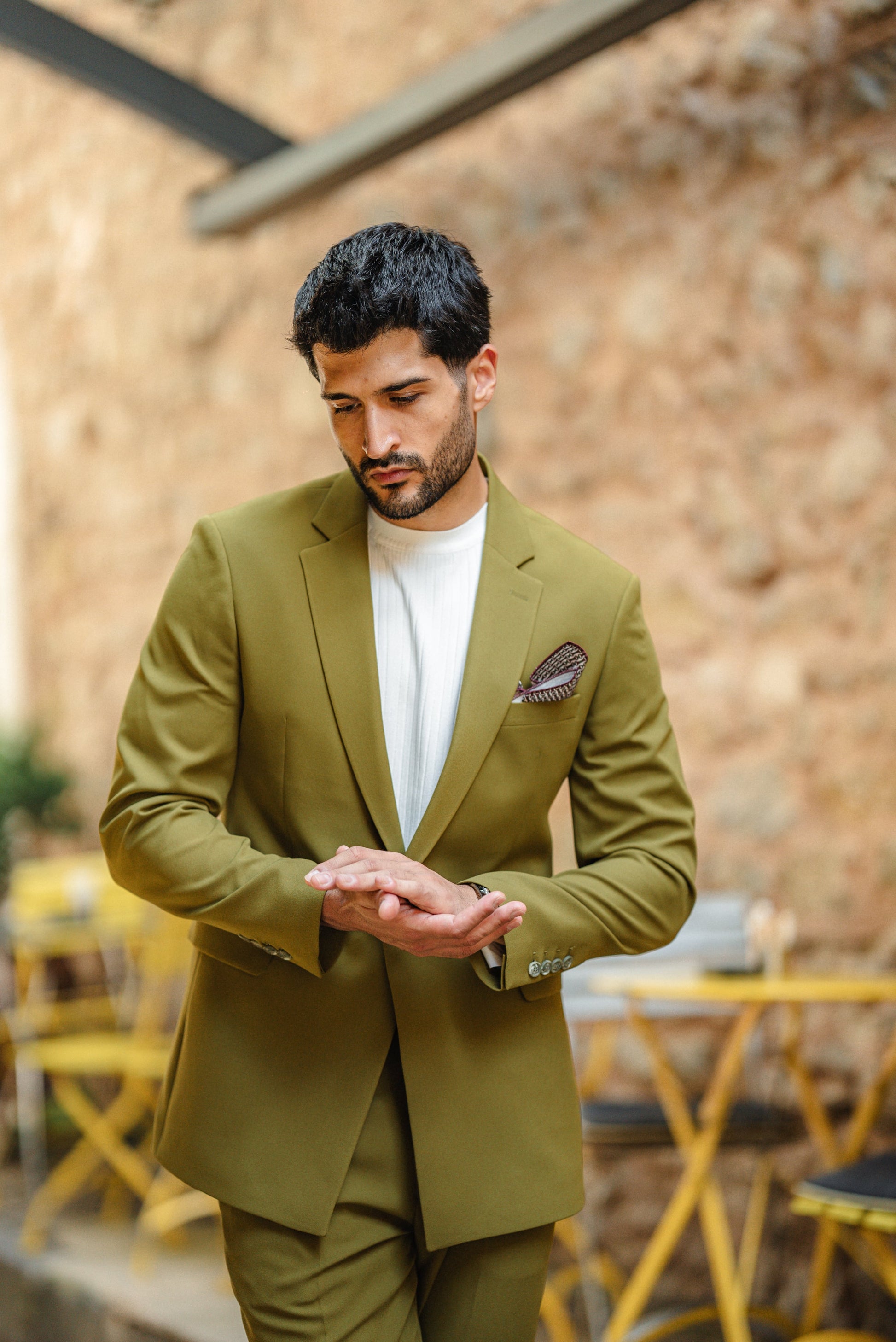 Man wearing the Bora Bora Olive Green Luxury Chain Detailed Suit with a white shirt and loafers, styled against a tropical summer backdrop.