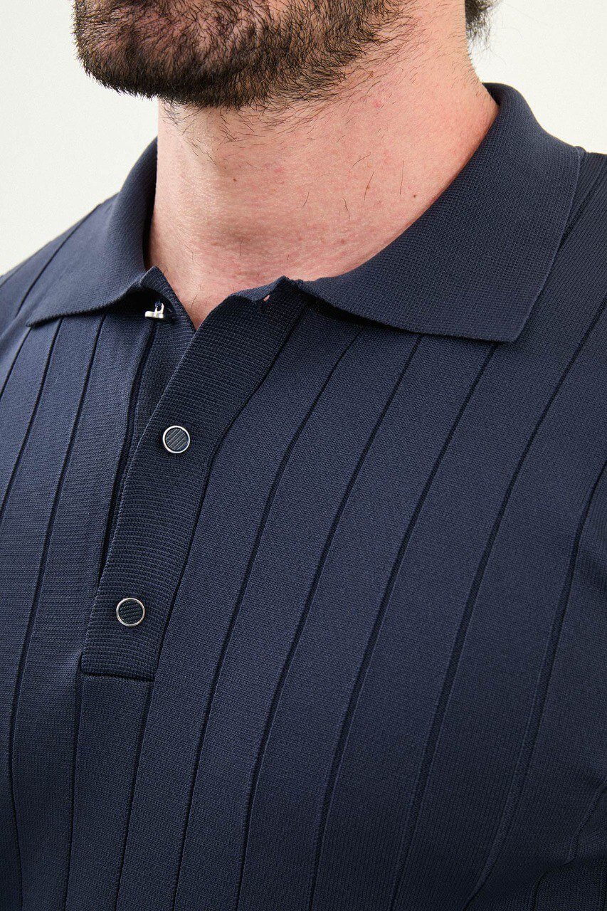 Men’s navy ribbed long-sleeve polo sweater with three-button placket and vertical rib knit texture, cotton-viscose stretch blend, styled with gray denim.