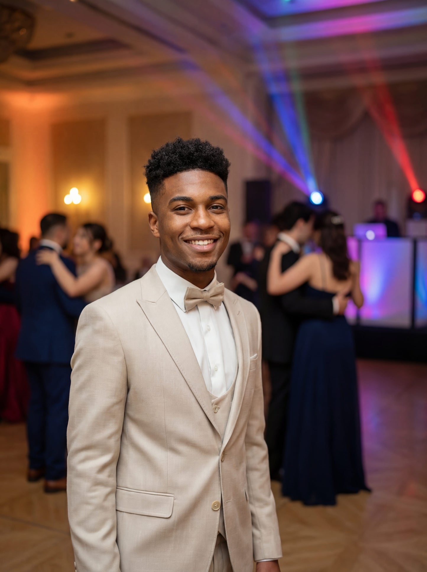 Ravishing Beige Teen Prom Tuxedo - Teen model wearing a slim fit beige tuxedo with bow tie, standing confidently at a formal event.