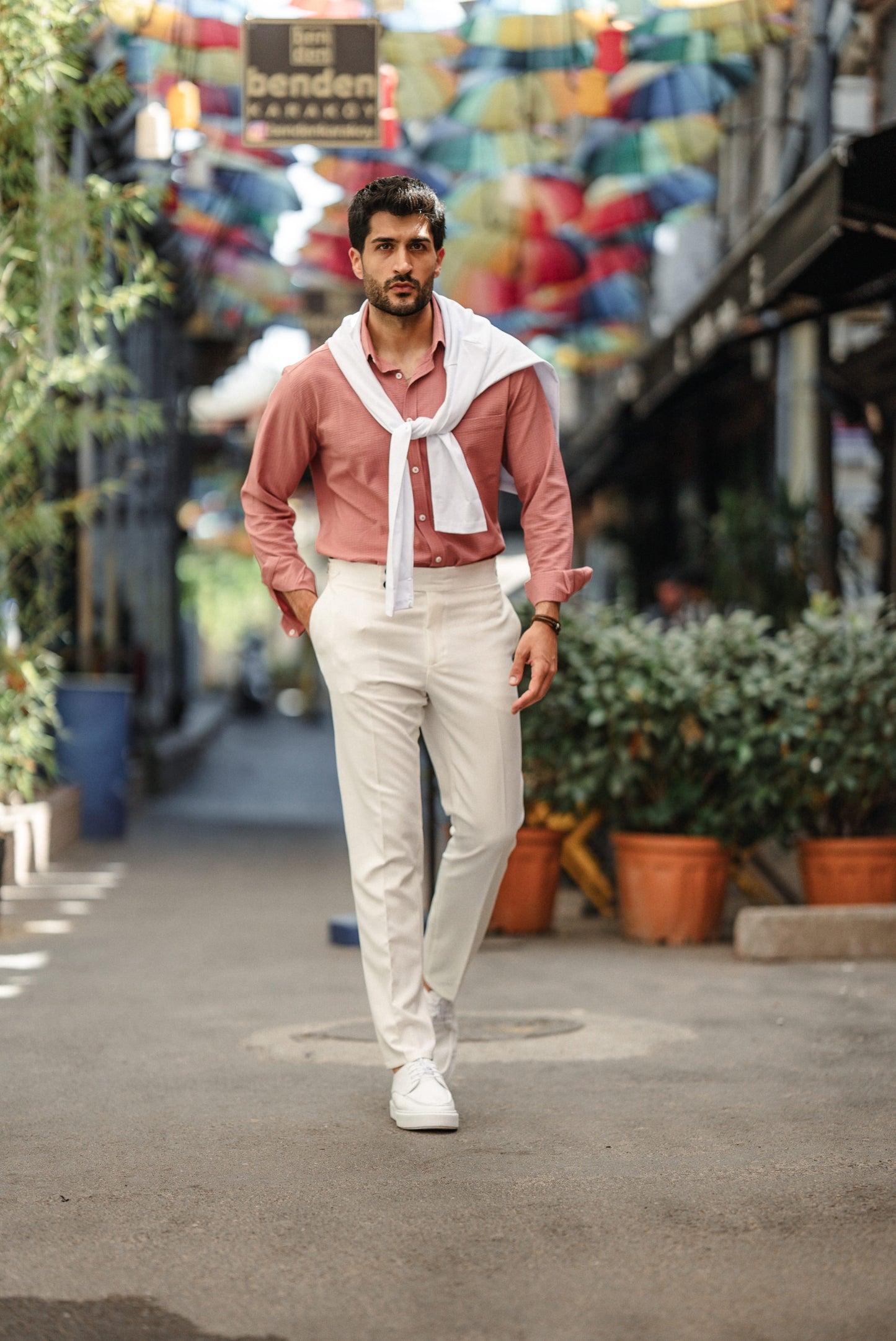 Man wearing the HolloMen Tulum Pink Linen Shirt, styled with a button-down collar, standing in a clean, minimal setting, perfect for summer occasions.