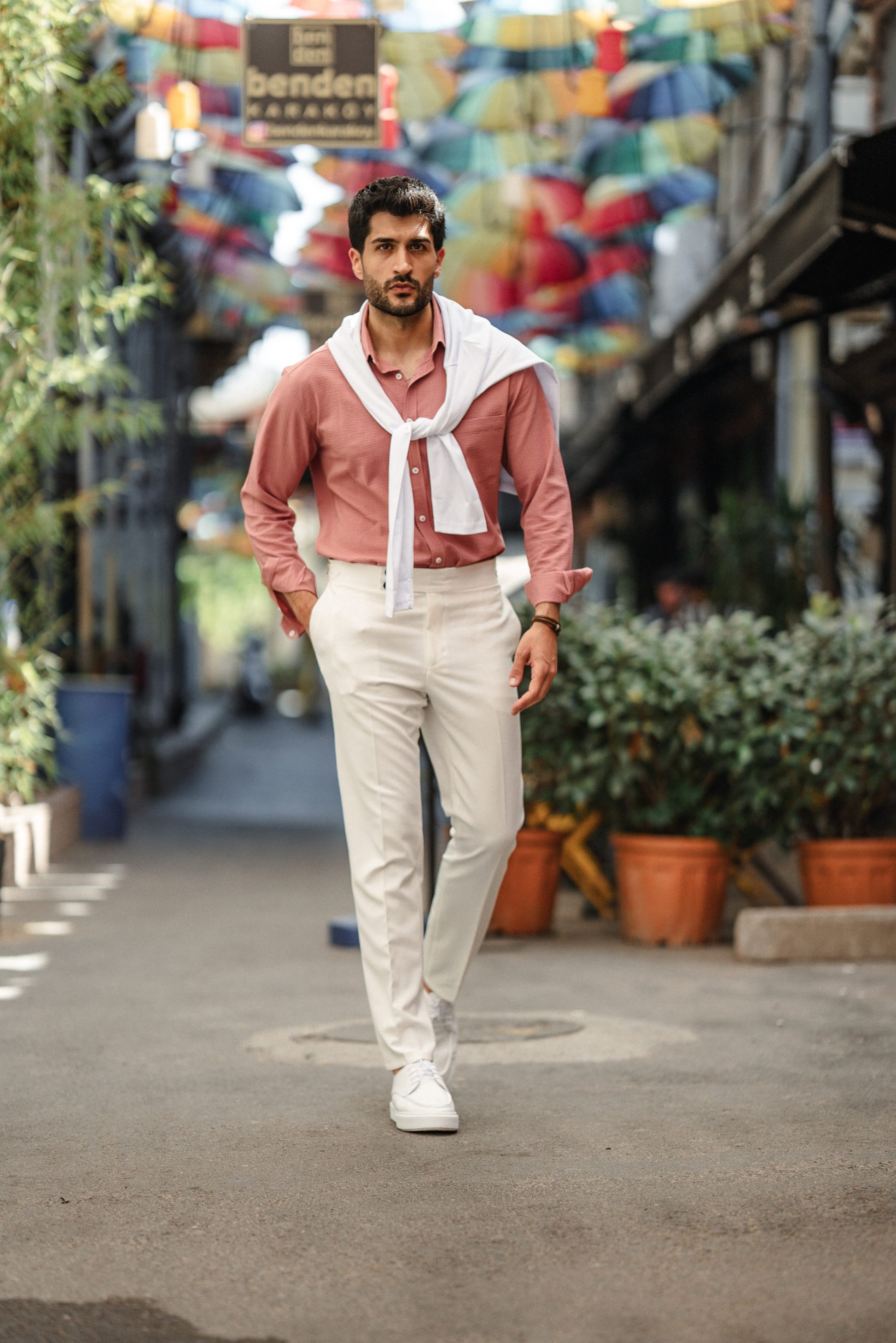 Man wearing the HolloMen Tulum Pink Linen Shirt, styled with a button-down collar, standing in a clean, minimal setting, perfect for summer occasions.